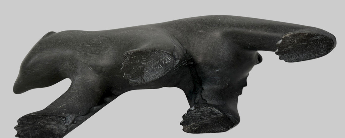 Signed Inuit soapstone bear by Joe Ittukalak (2004) from Nunavik. 10-inch Canadian carving in dark stone—authentic Indigenous art sculpture.