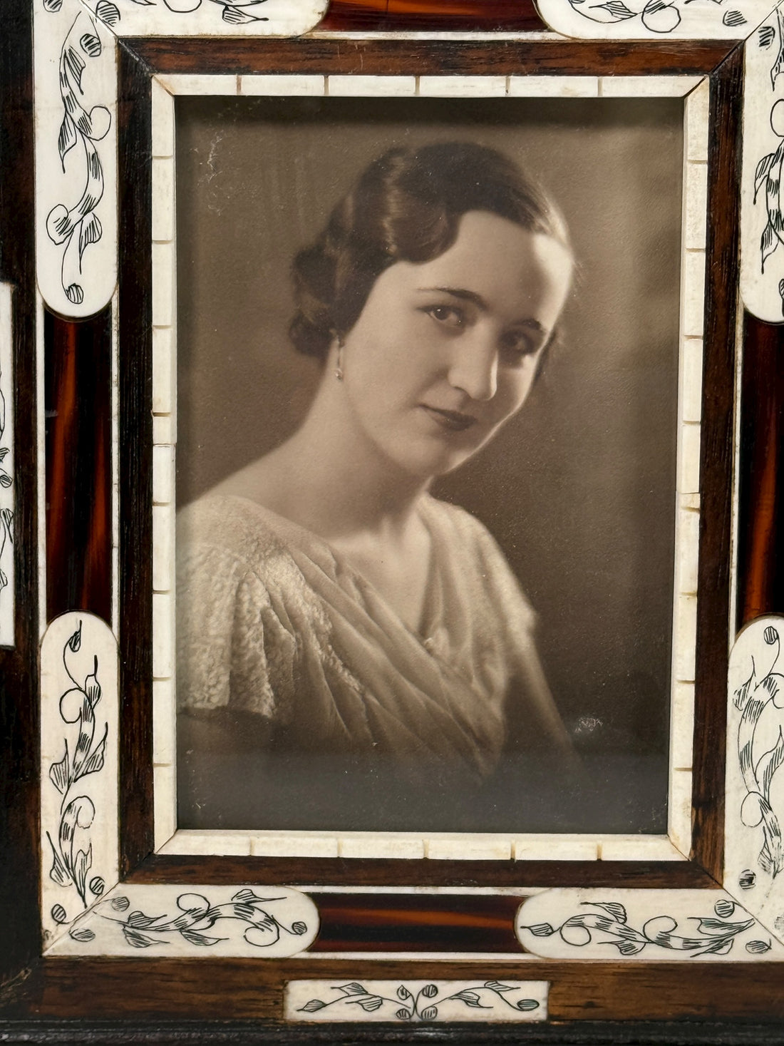 Vintage portrait of a woman in a decorative frame with floral patterns