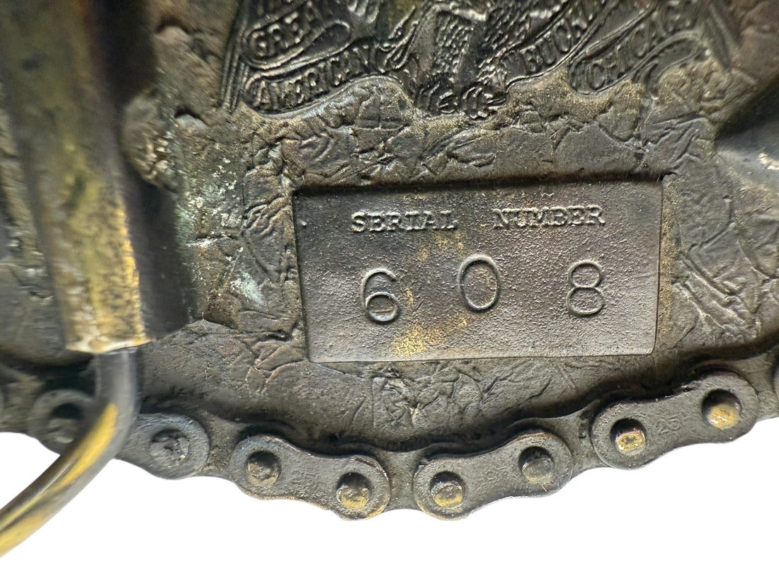 Close-up of a metal chain with a rectangular tag featuring the number '809' on a textured background.