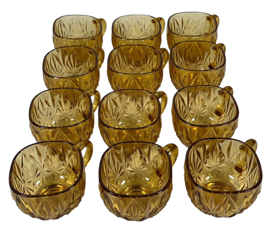 Vintage mid-century amber glass punch bowl set with cups and ladle. Classic starburst pattern, complete set, perfect for retro entertaining.