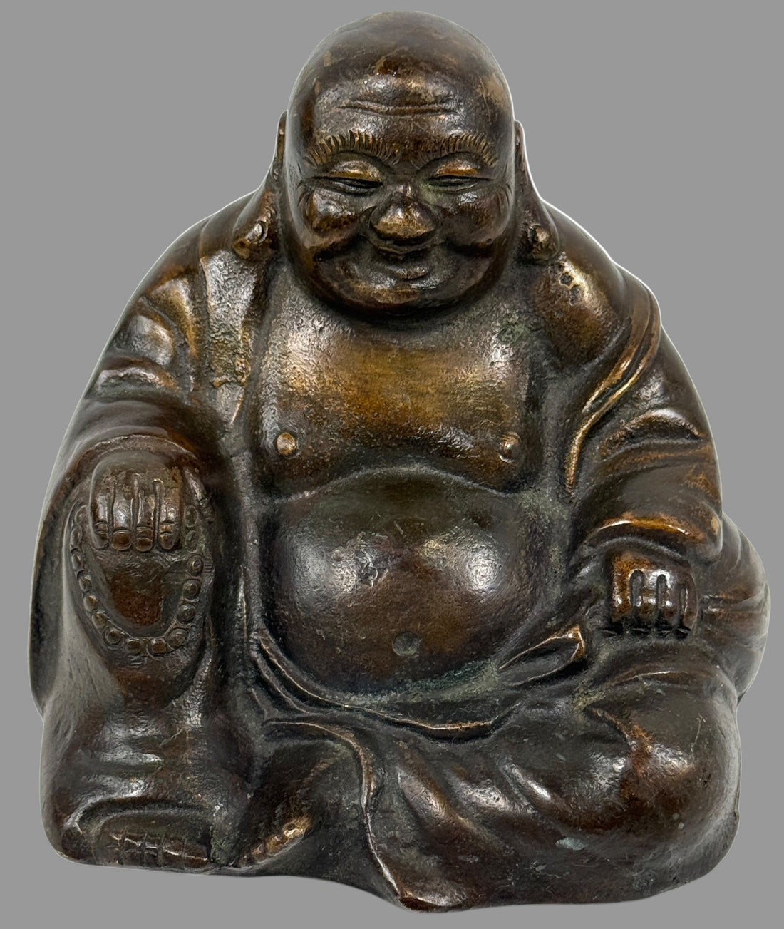 Bronze statue of a smiling Buddha figure on a white background