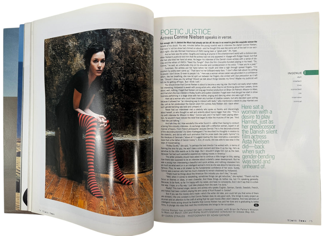 Open book with a photograph of a woman in striped stockings and text on a wooden floor.