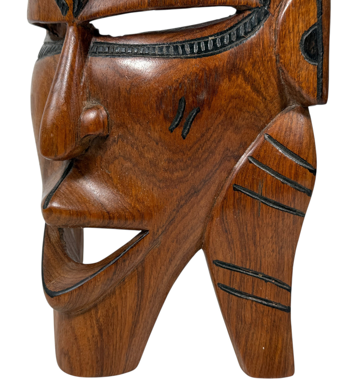 Wooden mask with detailed carvings on a white background