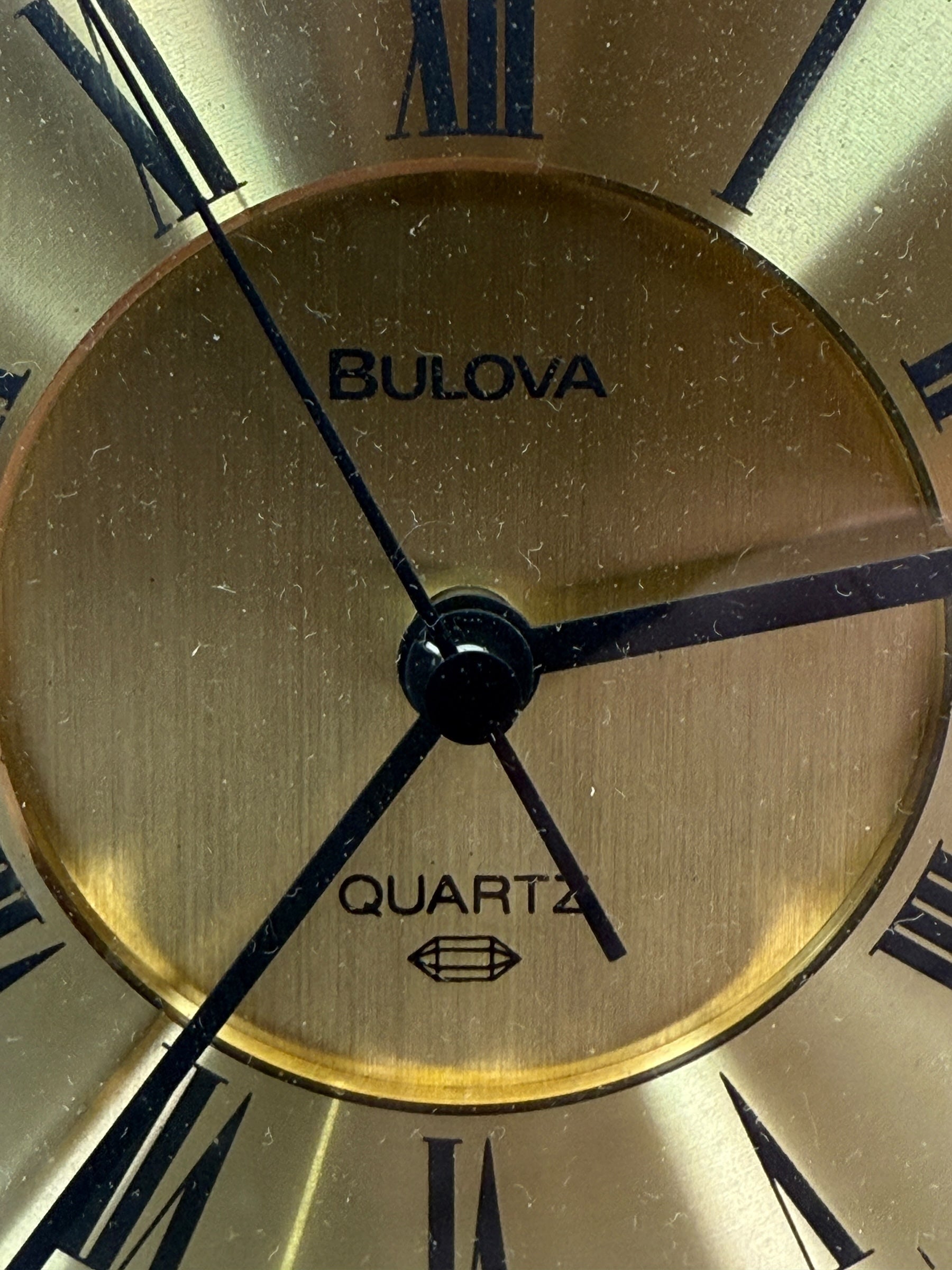 Close-up of a Bulova watch face with gold and black details.