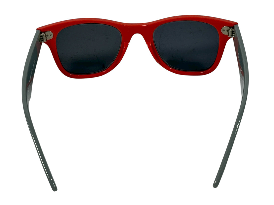 Red sunglasses with dark lenses on a white background