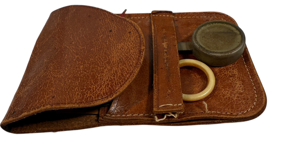 Brown leather case with a ring and round object on a white background