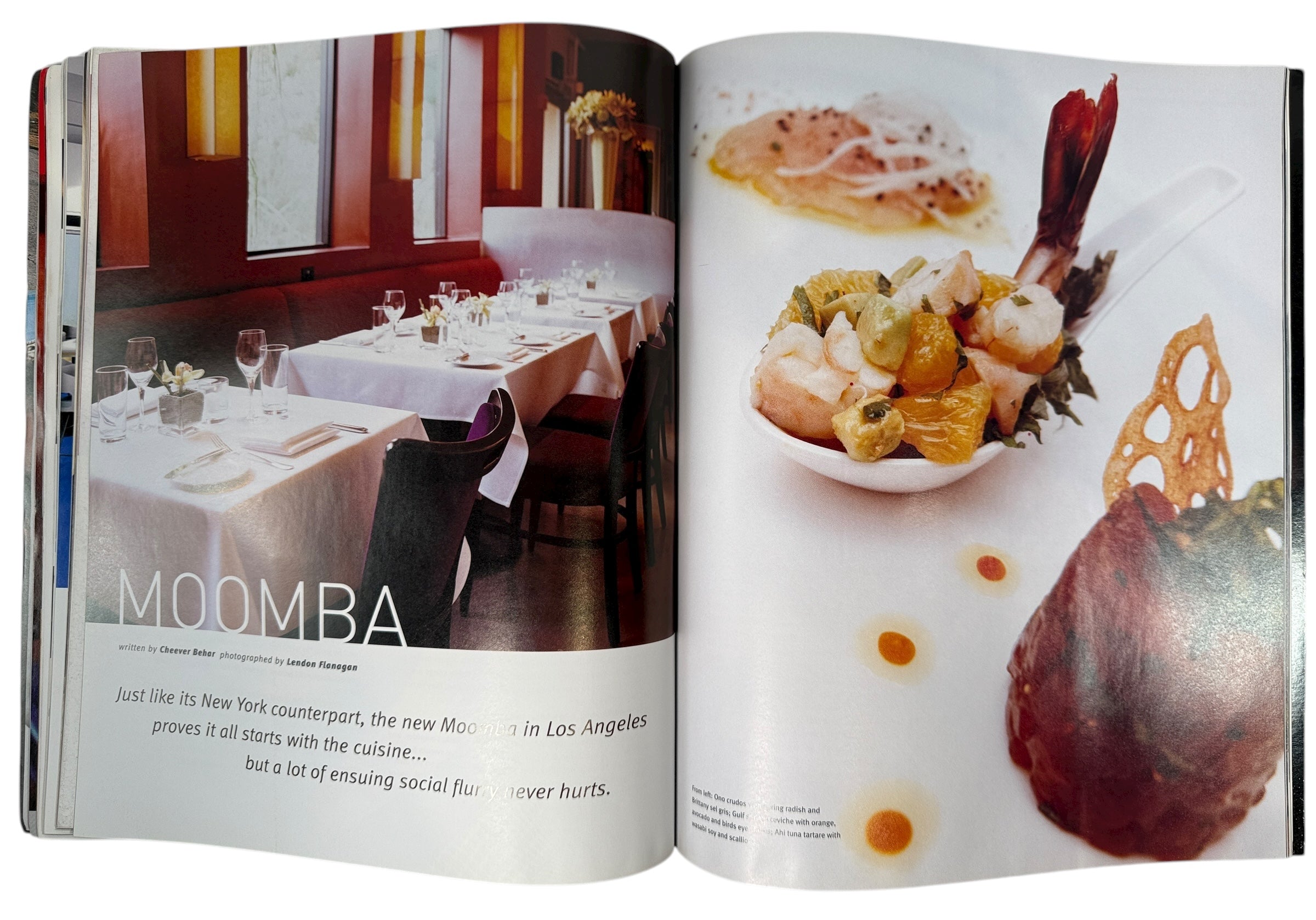Open magazine showing a restaurant interior and food dishes.