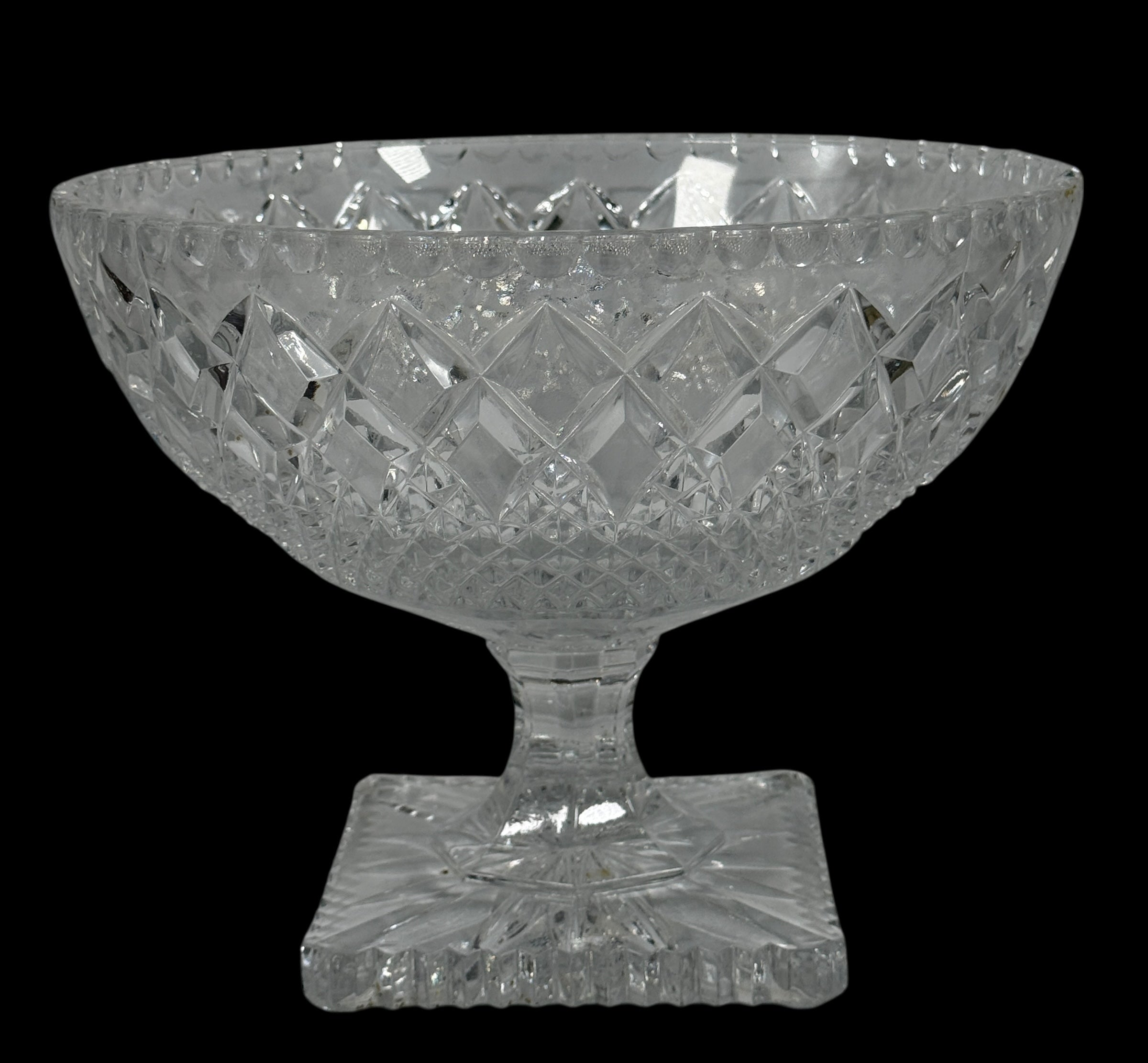 Clear glass bowl with diamond cut pattern on a black background