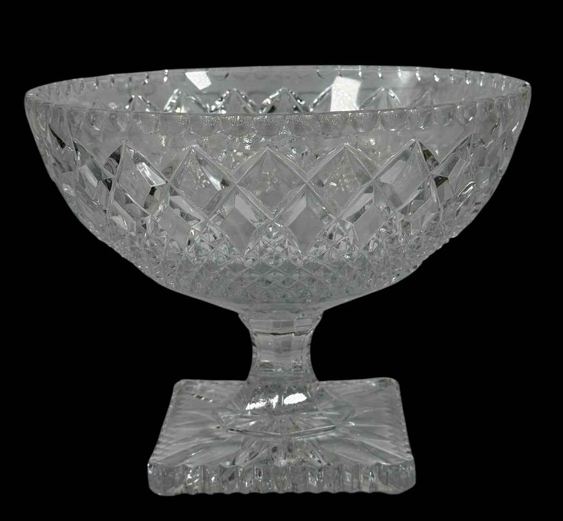 Clear glass bowl with diamond cut pattern on a black background