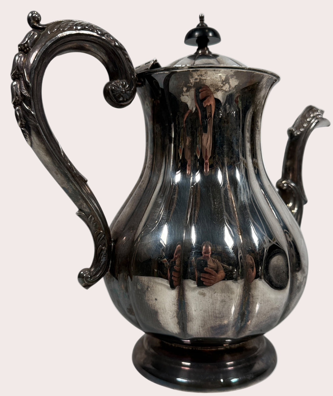 Silver coffee pot with intricate design on a white background