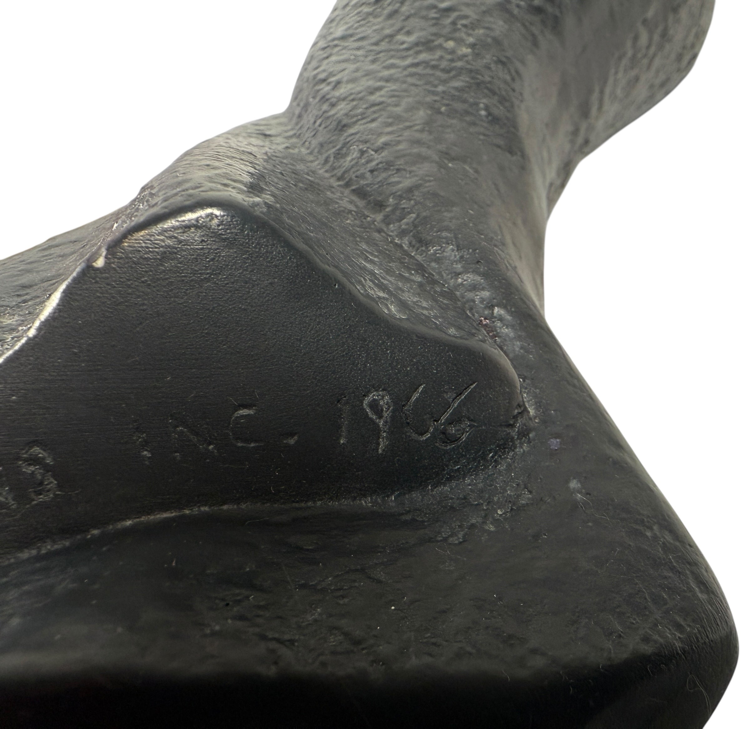 Close-up of a black cast iron product with 'B & C. 1968' engraving on a white background