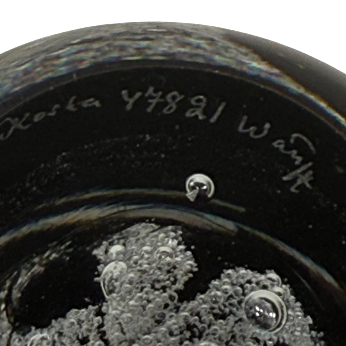 Close-up of a Kosta Boda glass bowl with visible branding and signature.