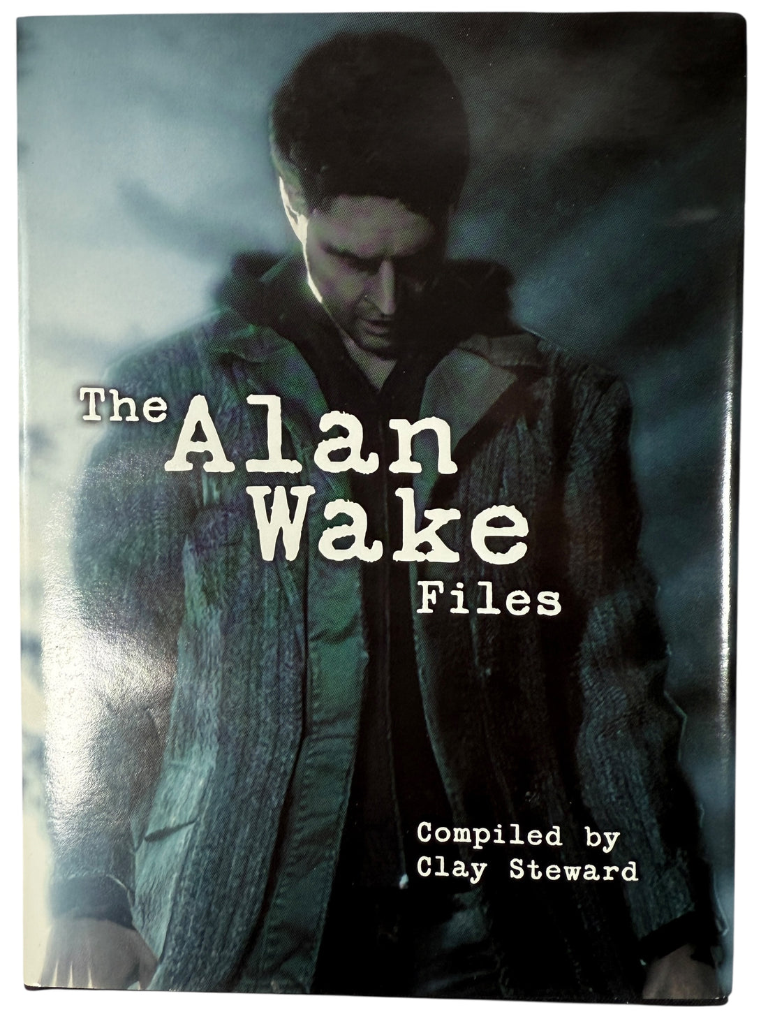 Book cover of 'The Alan Wake Files' with a character in a jacket and scarf.