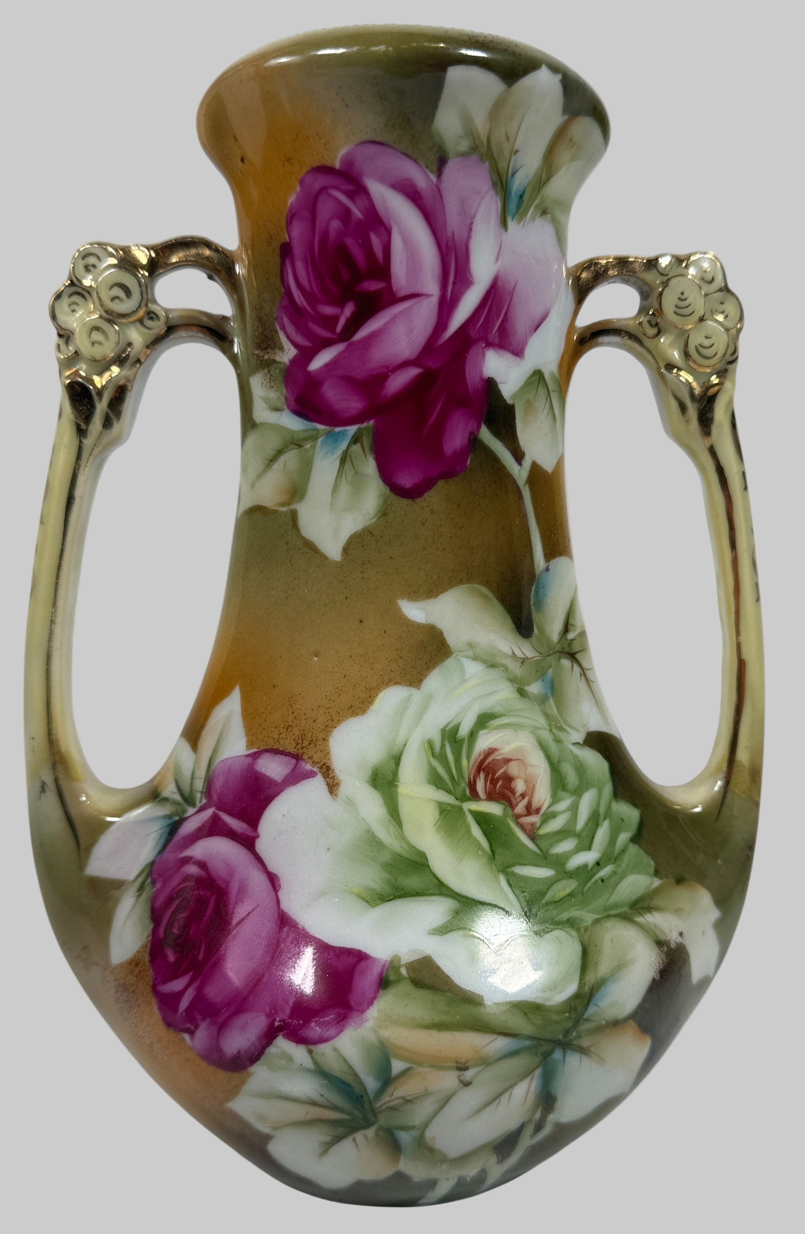 Decorative vase with floral designs and gold handles on a white background