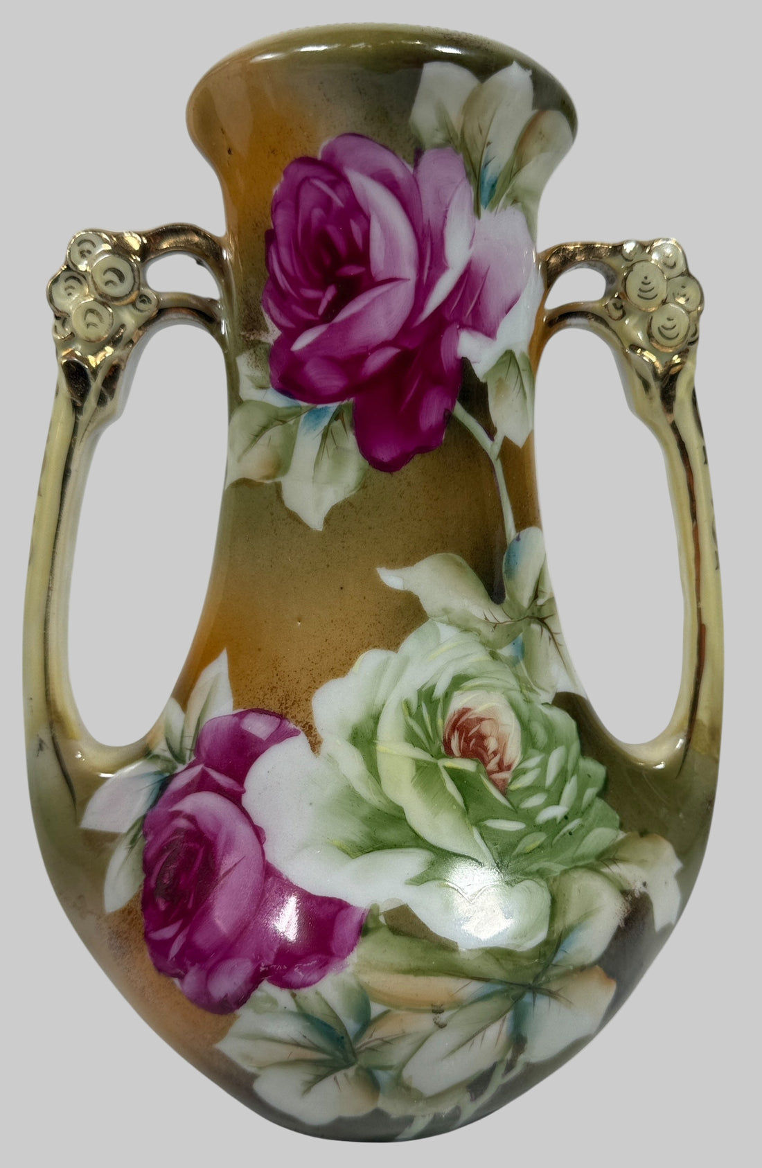 Decorative vase with floral designs and gold handles on a white background