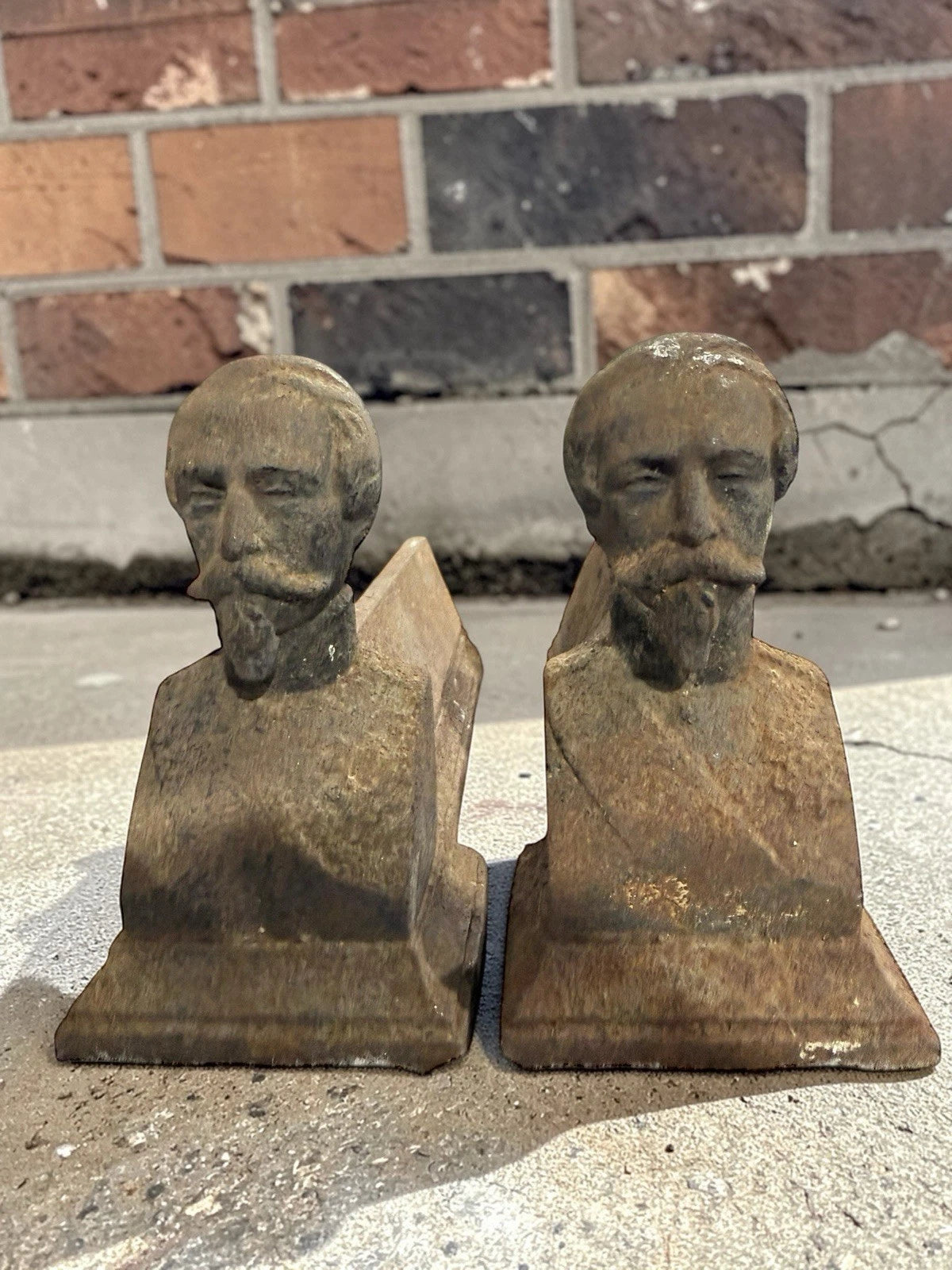 Antique French cast iron chenets with male bust fronts. Decorative fireplace firedogs / andirons with aged black patina and historic hearth appeal.