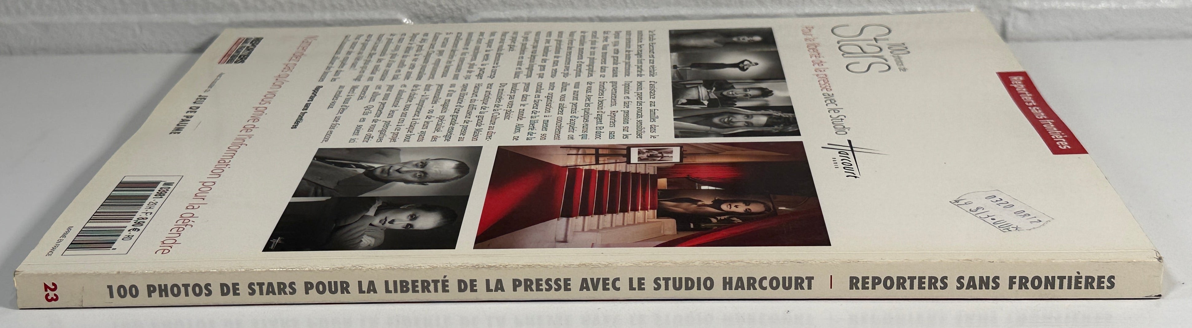 Book lying flat on a white surface with a gray brick wall background