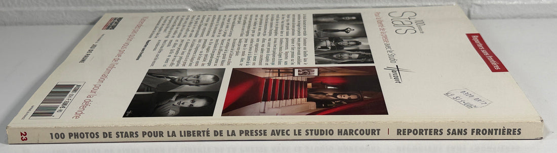 Book lying flat on a white surface with a gray brick wall background