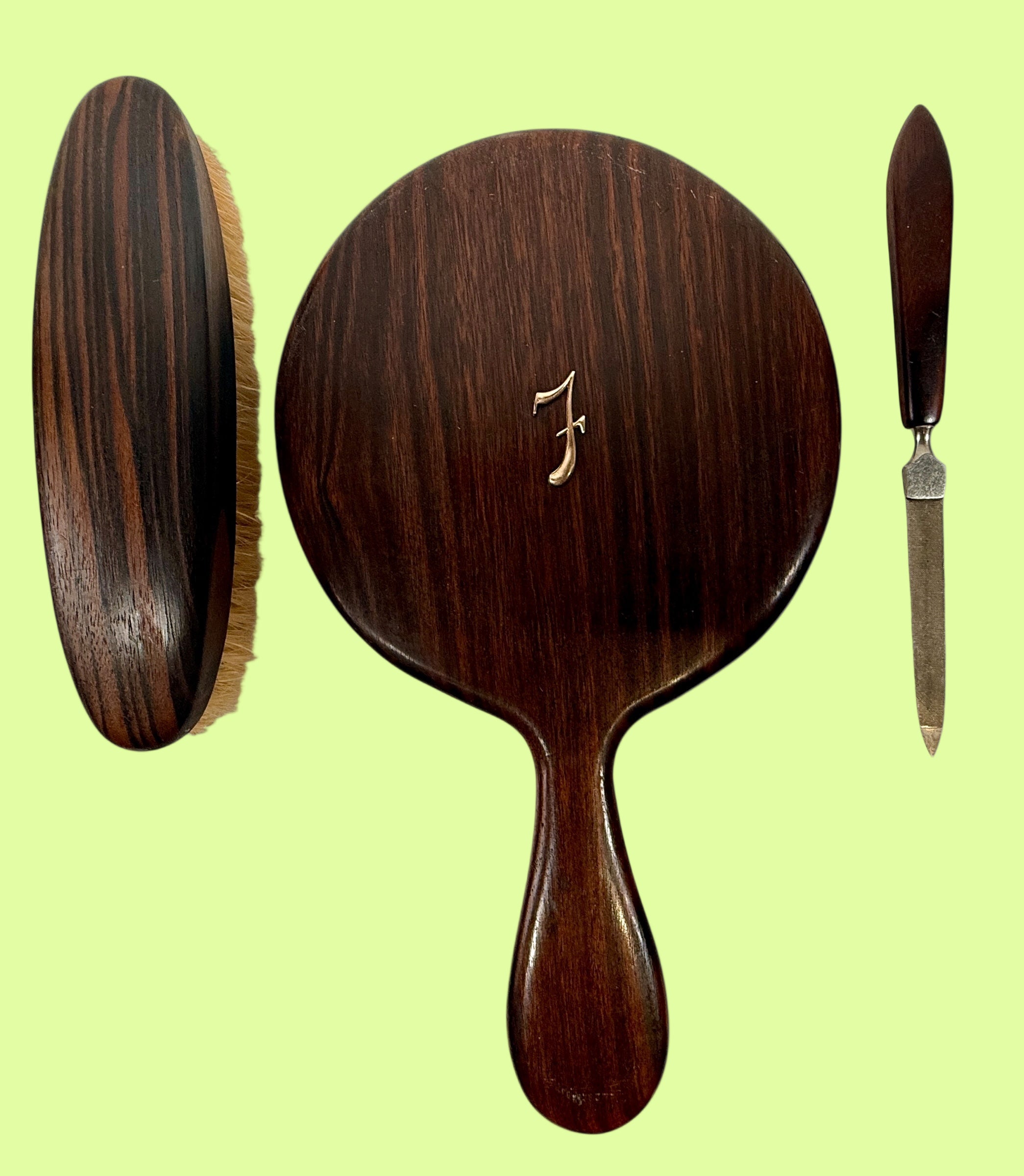Set of wooden hairbrush, hand mirror, and knife on a white background