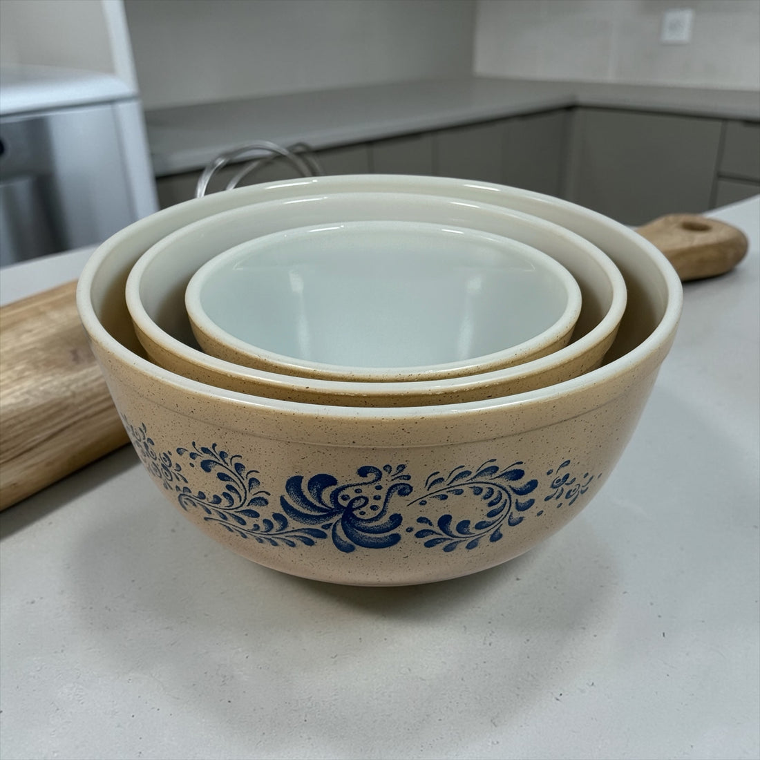Vintage Pyrex Homestead blue floral mixing bowls and casserole dishes with lids. Classic farmhouse kitchenware set, durable glass, collectible and practical.