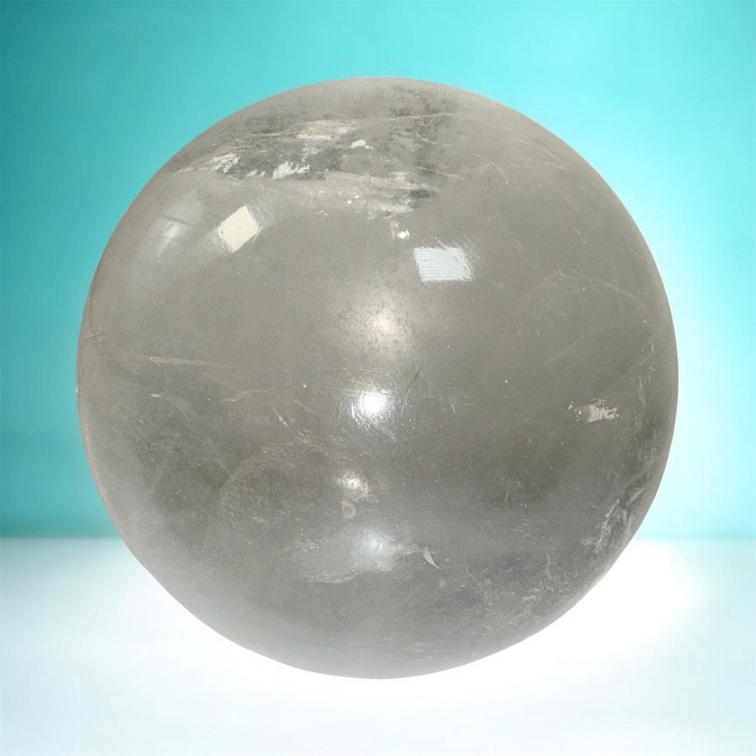 Natural clear quartz crystal sphere 70mm polished orb with beautiful internal veils and inclusions. Decorative display piece for collectors or décor.