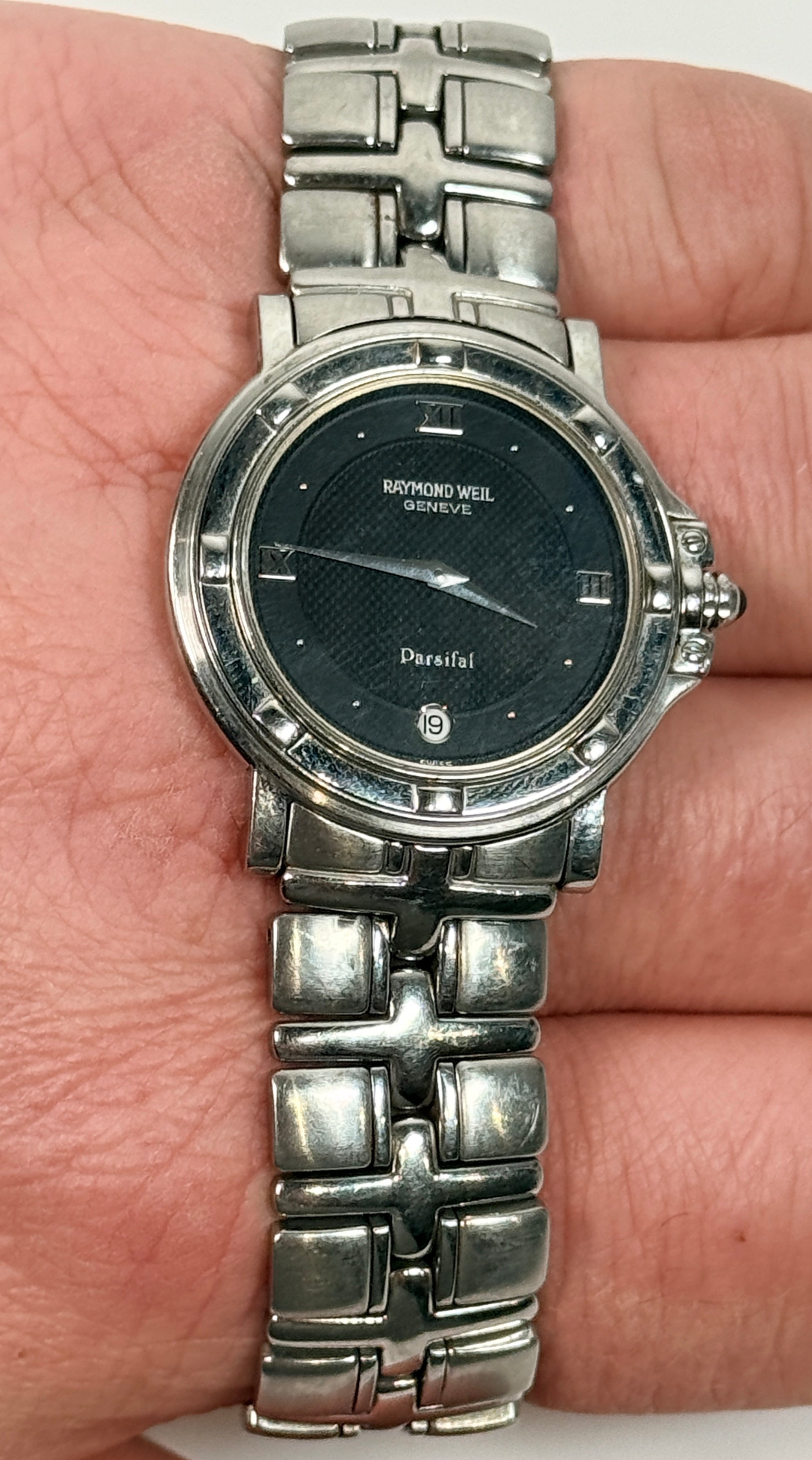Raymond Weil Parsifal Swiss quartz watch with black dial, Roman numerals, and steel bracelet. Classic luxury design with date display, everyday wearable style.