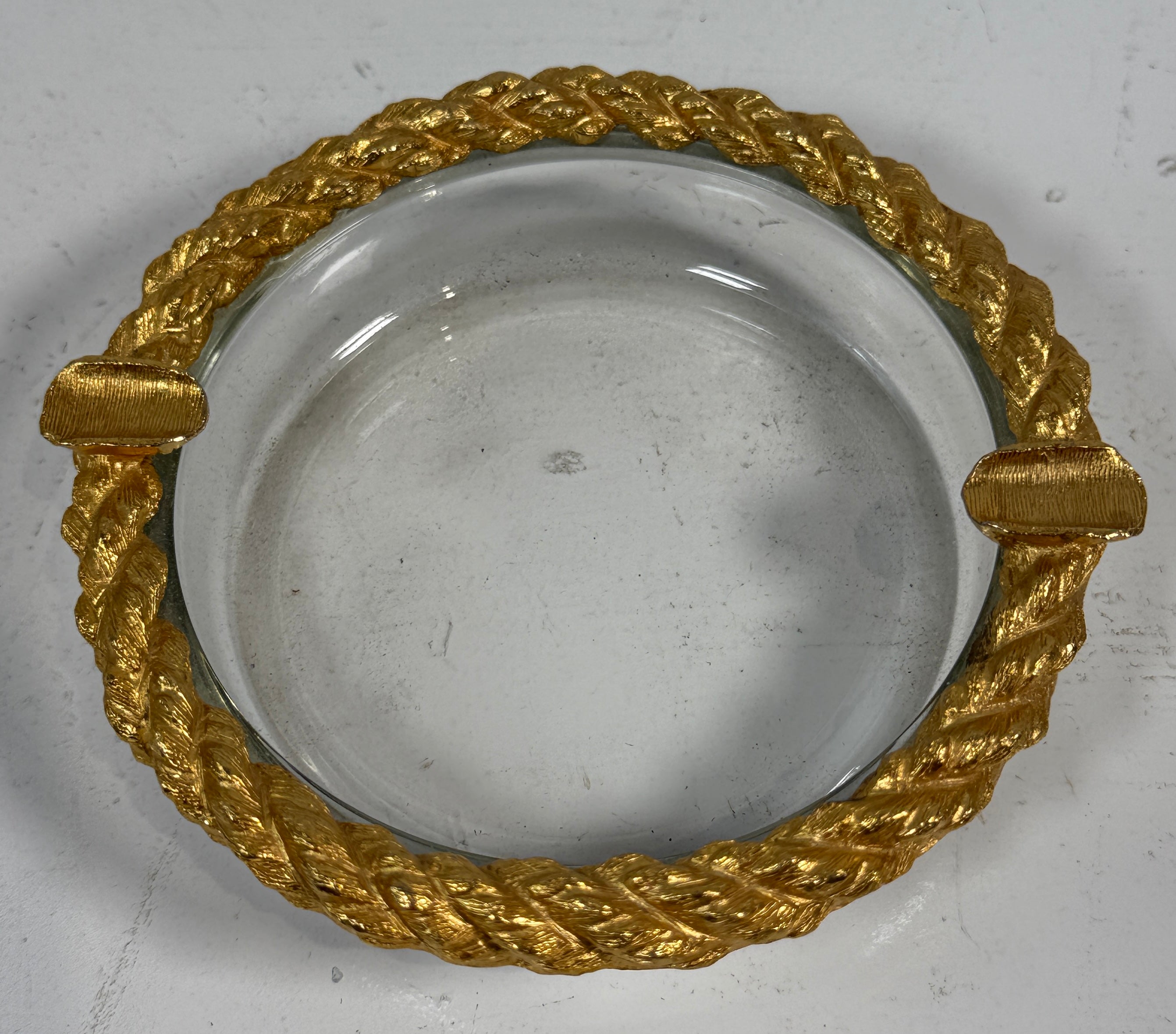 Decorative glass plate with gold metallic rim on a gray background
