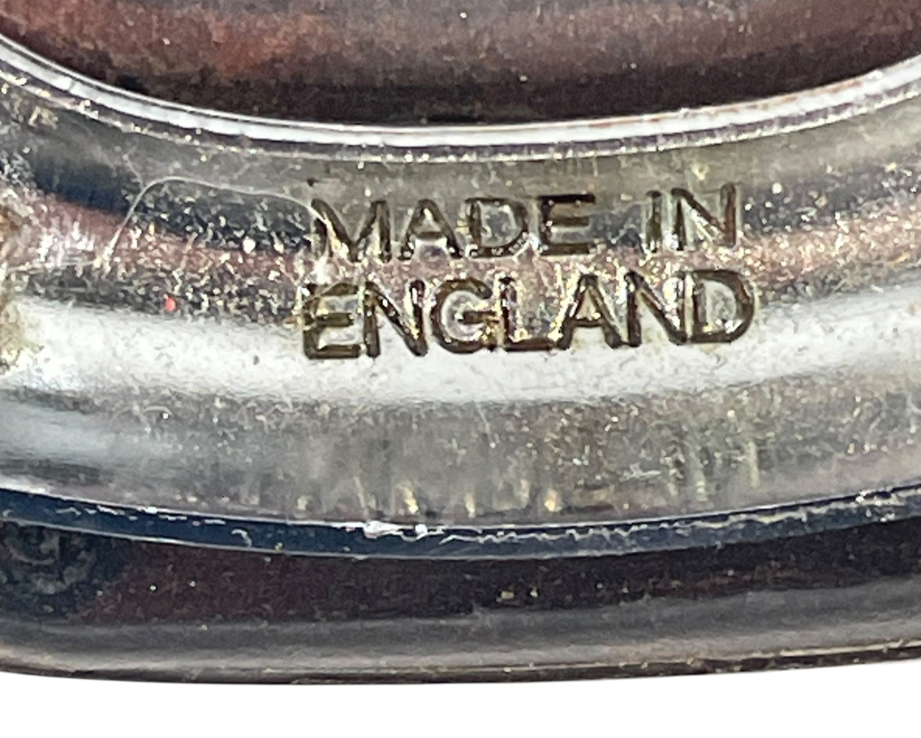 Close-up of a metal object with 'MADE IN ENGLAND' engraving.