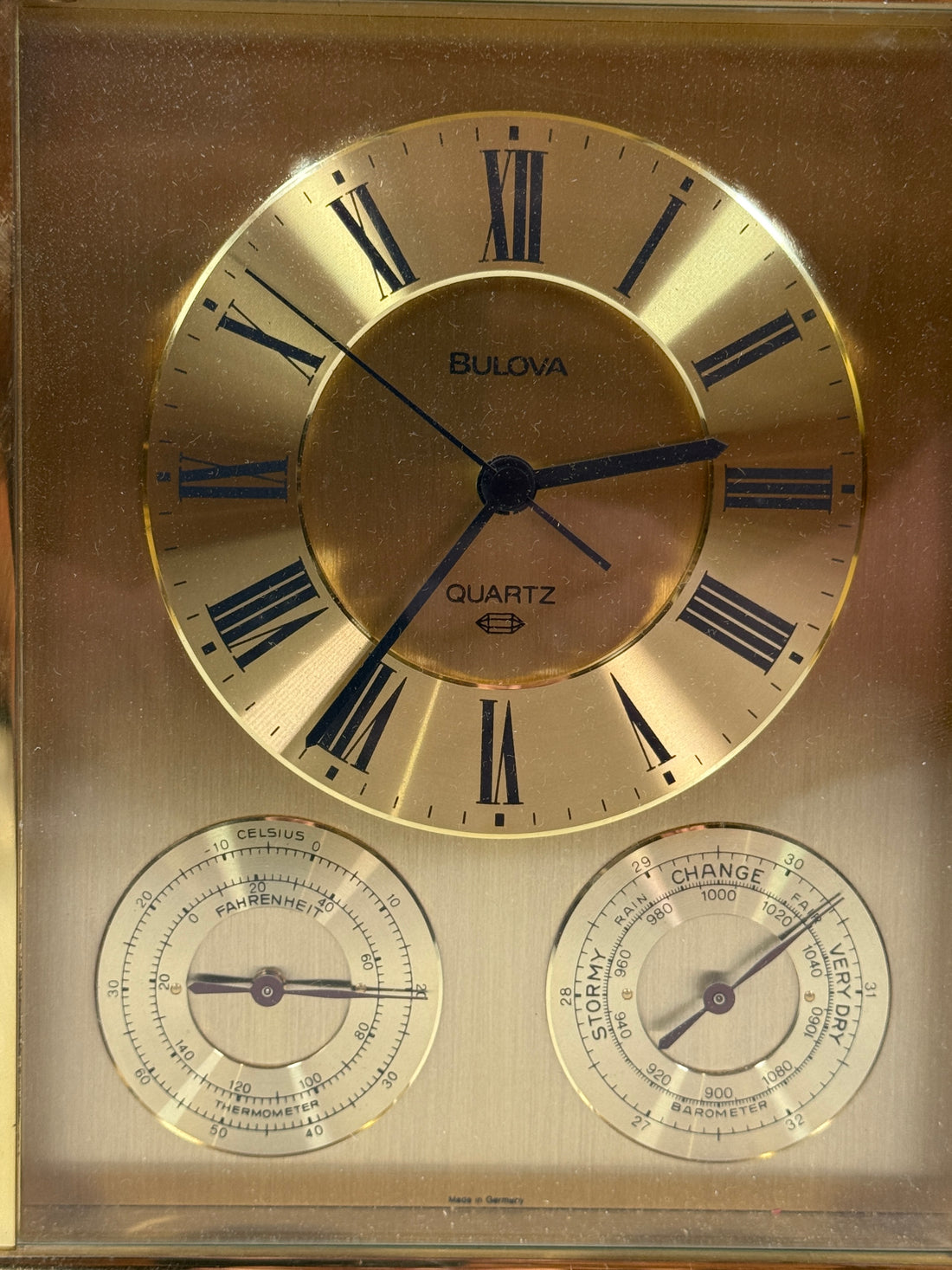 Vintage Bulova clock with barometer and thermometer on a gold background