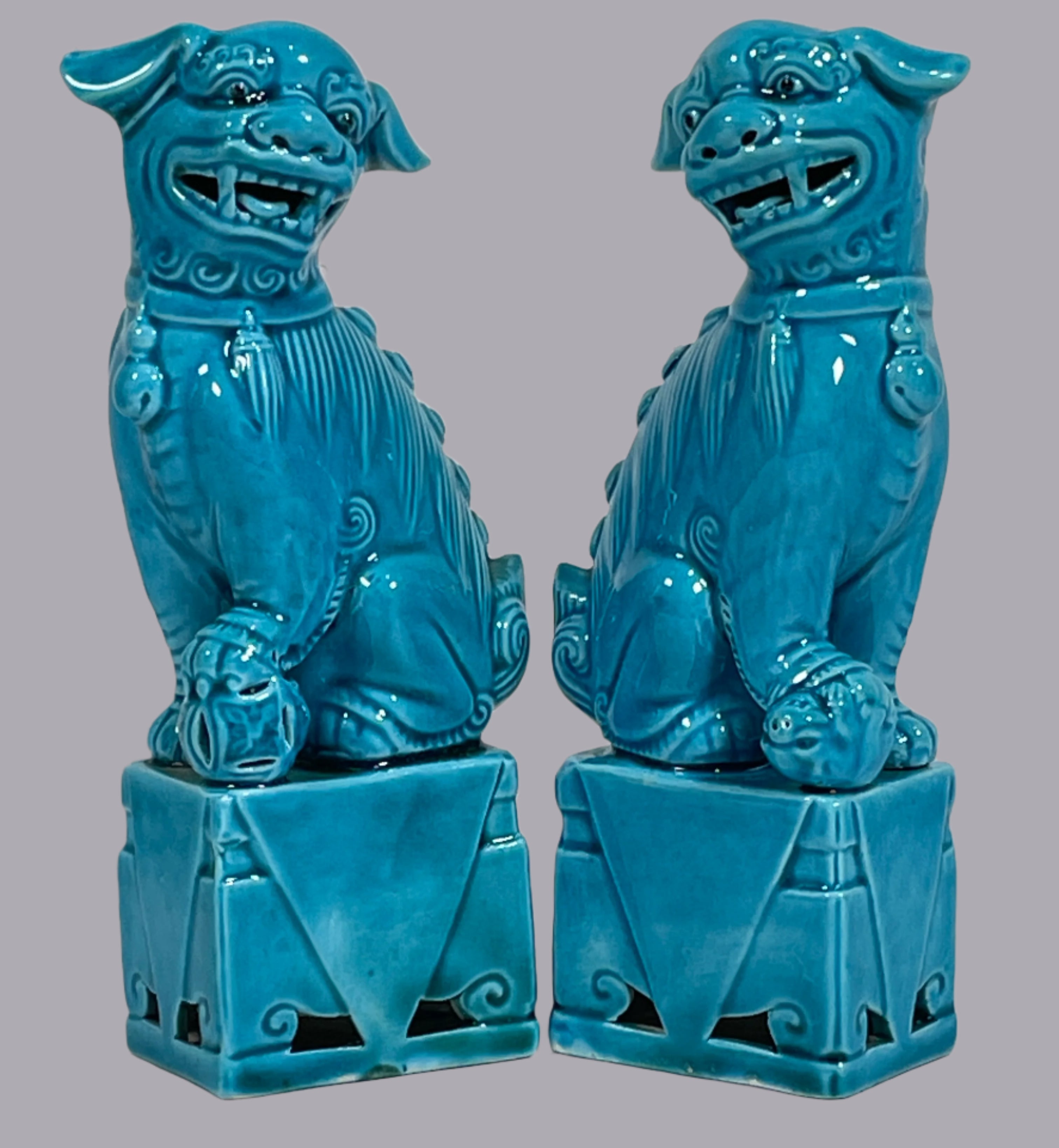 Two blue ceramic figures on a textured white background