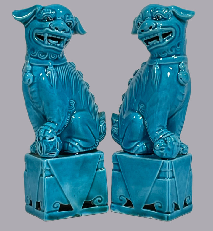 Two blue ceramic figures on a textured white background