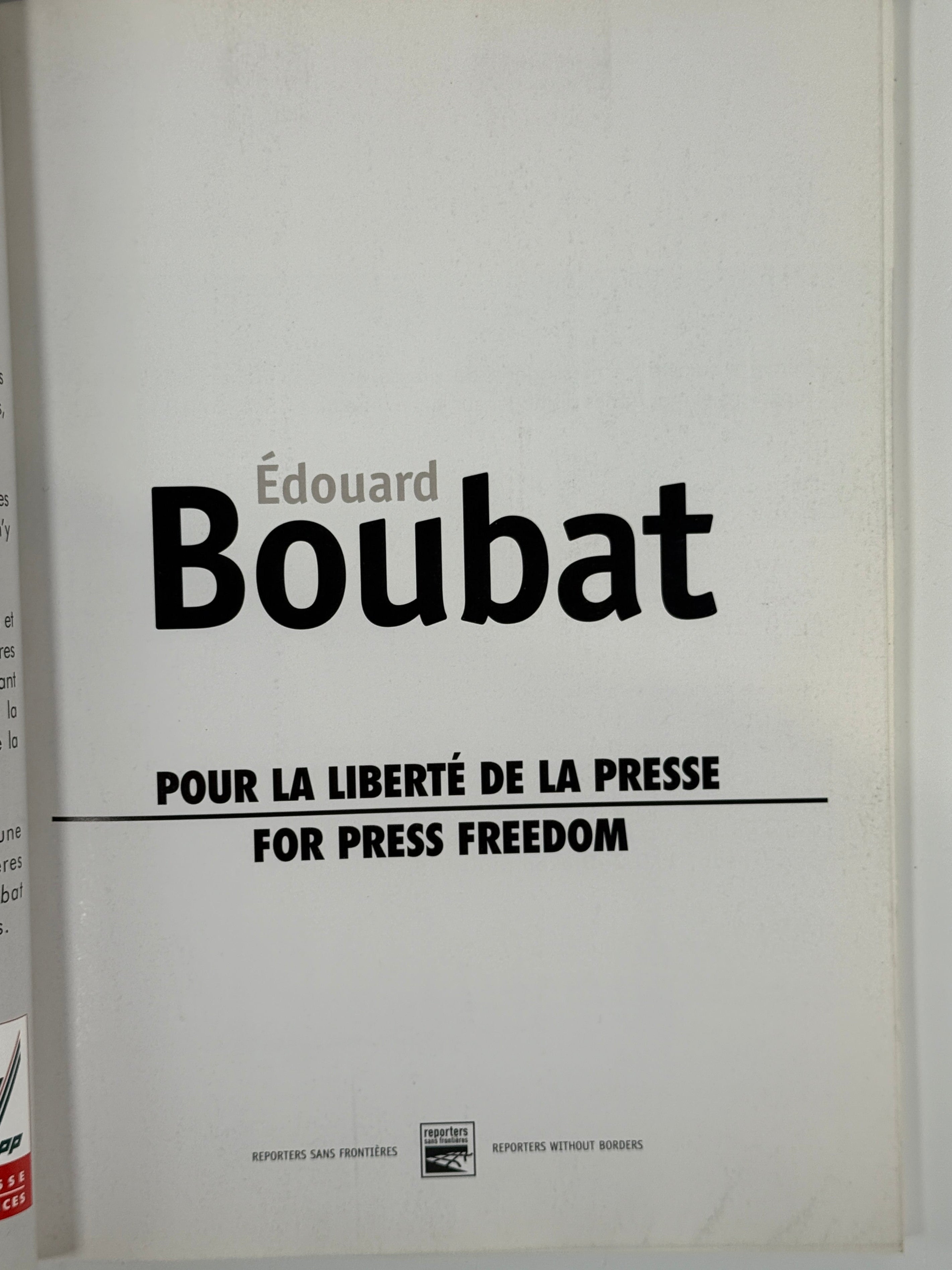 Book or document with 'Edouard Boubat' and 'Pour la Liberte de la Presse' text on a white background