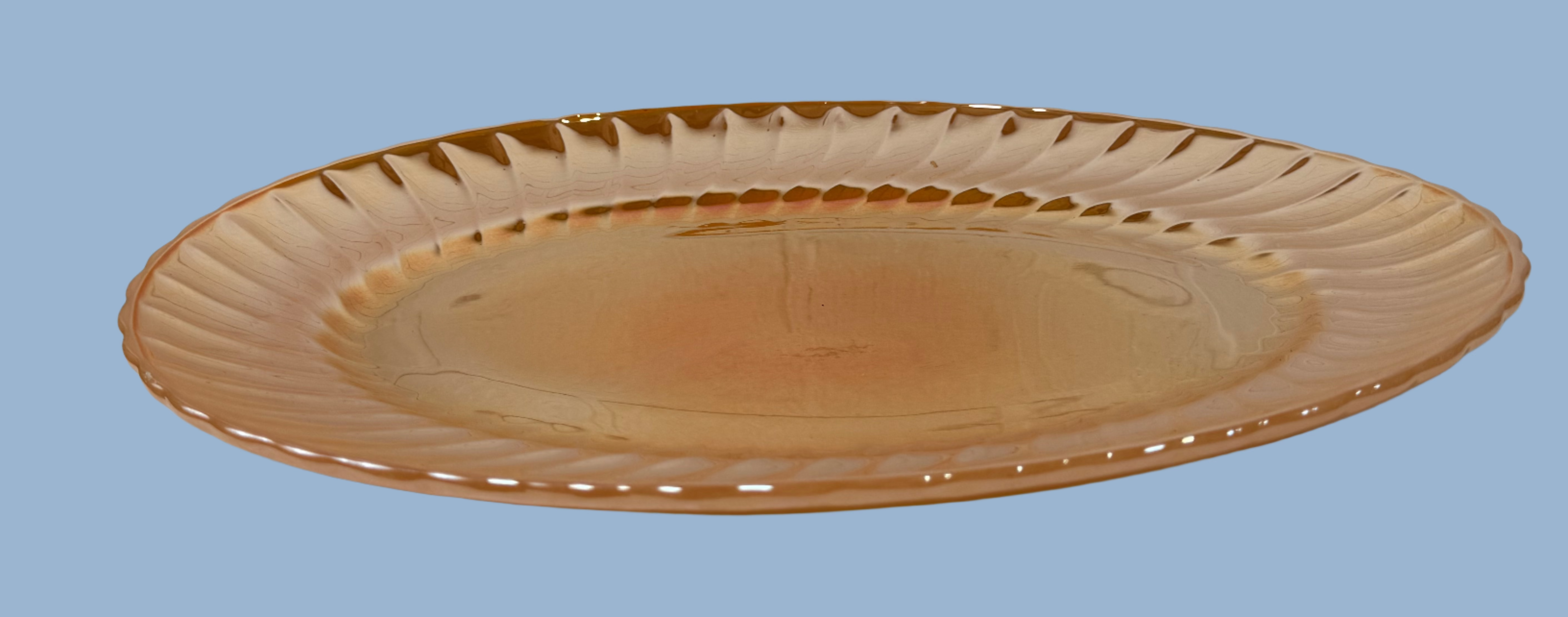 Brown ceramic plate on a white surface with a light gray brick wall background