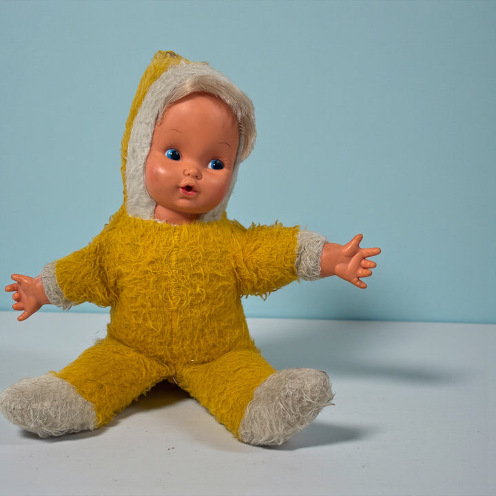 Vintage 1950s wind-up musical baby doll in yellow plush suit with vinyl face. Music plays well. Great display collectible. Ships from Canada.
