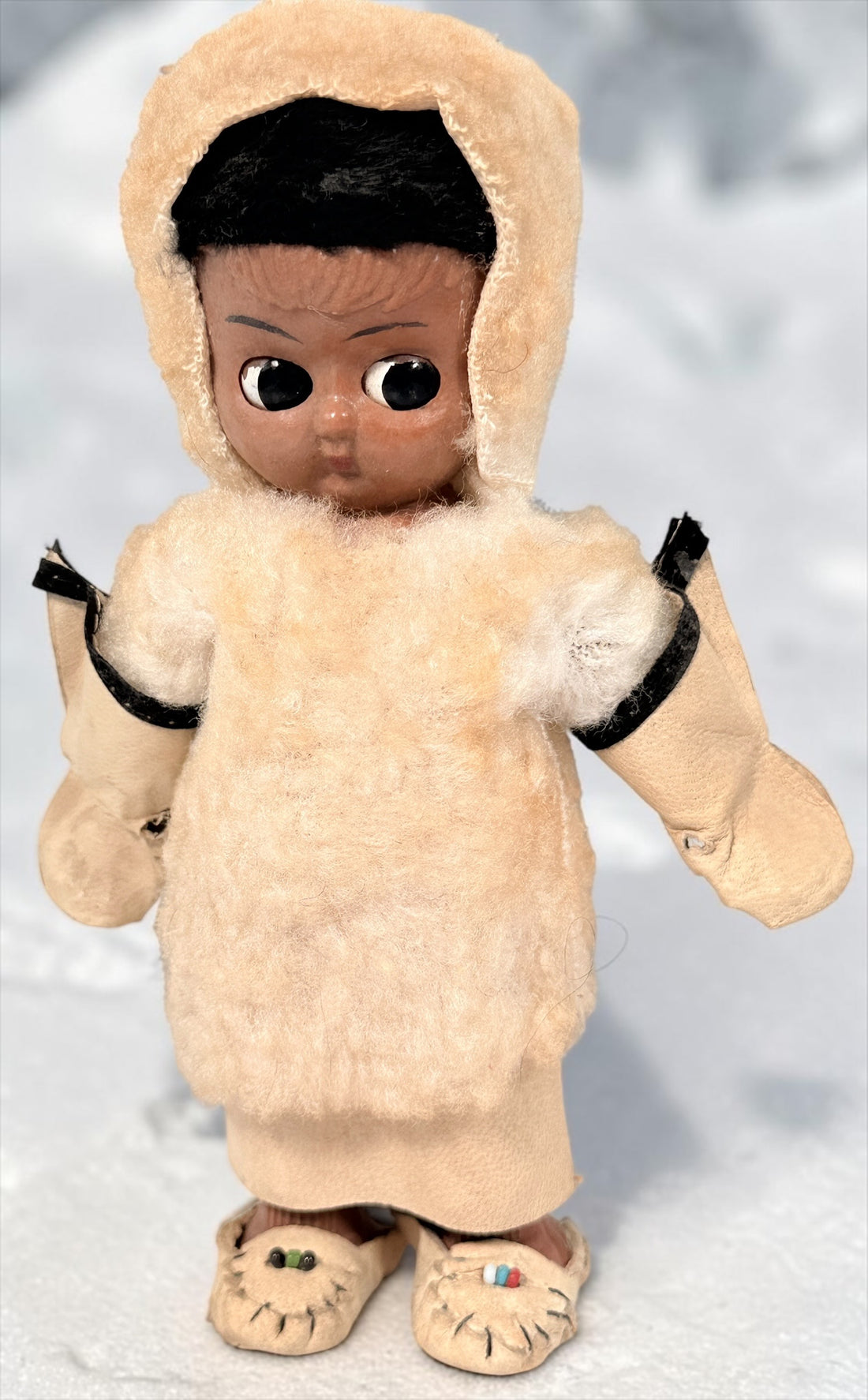 Vintage Hong Kong Inuit-style souvenir doll with sleep eyes, faux-fur parka and beaded footwear. 1960s–1970s collectible in worn condition.