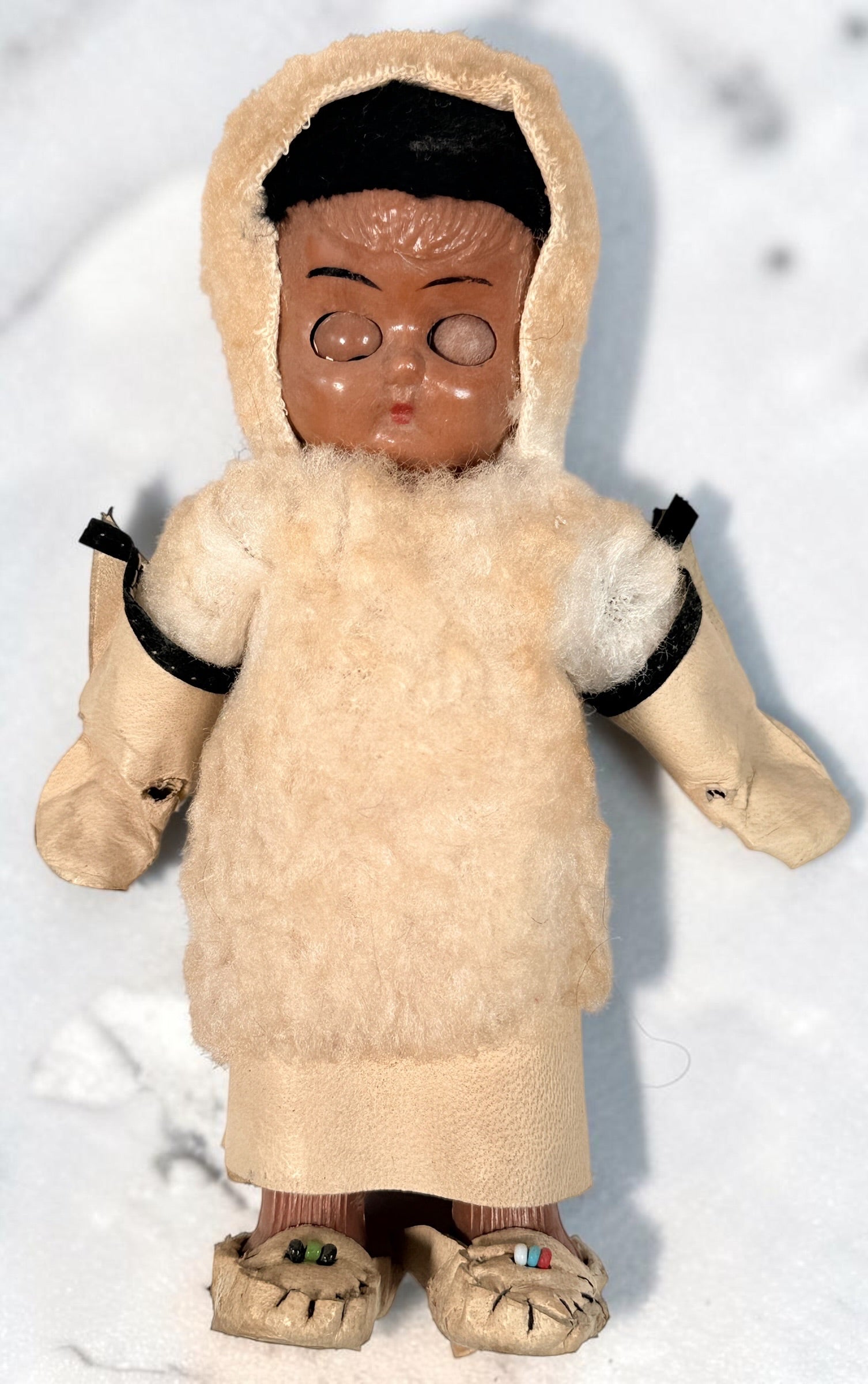 Vintage Hong Kong Inuit-style souvenir doll with sleep eyes, faux-fur parka and beaded footwear. 1960s–1970s collectible in worn condition.
