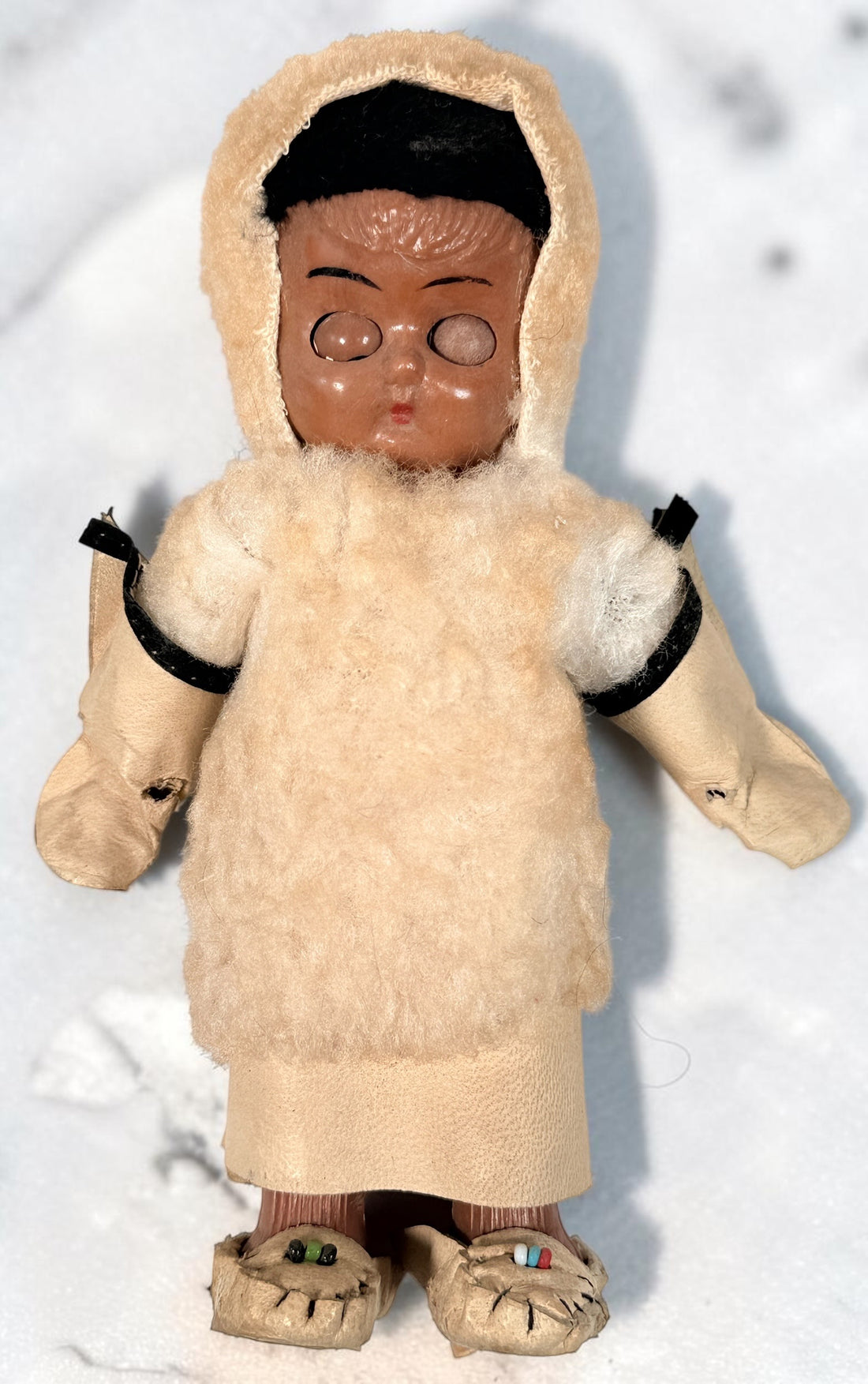 Vintage Hong Kong Inuit-style souvenir doll with sleep eyes, faux-fur parka and beaded footwear. 1960s–1970s collectible in worn condition.