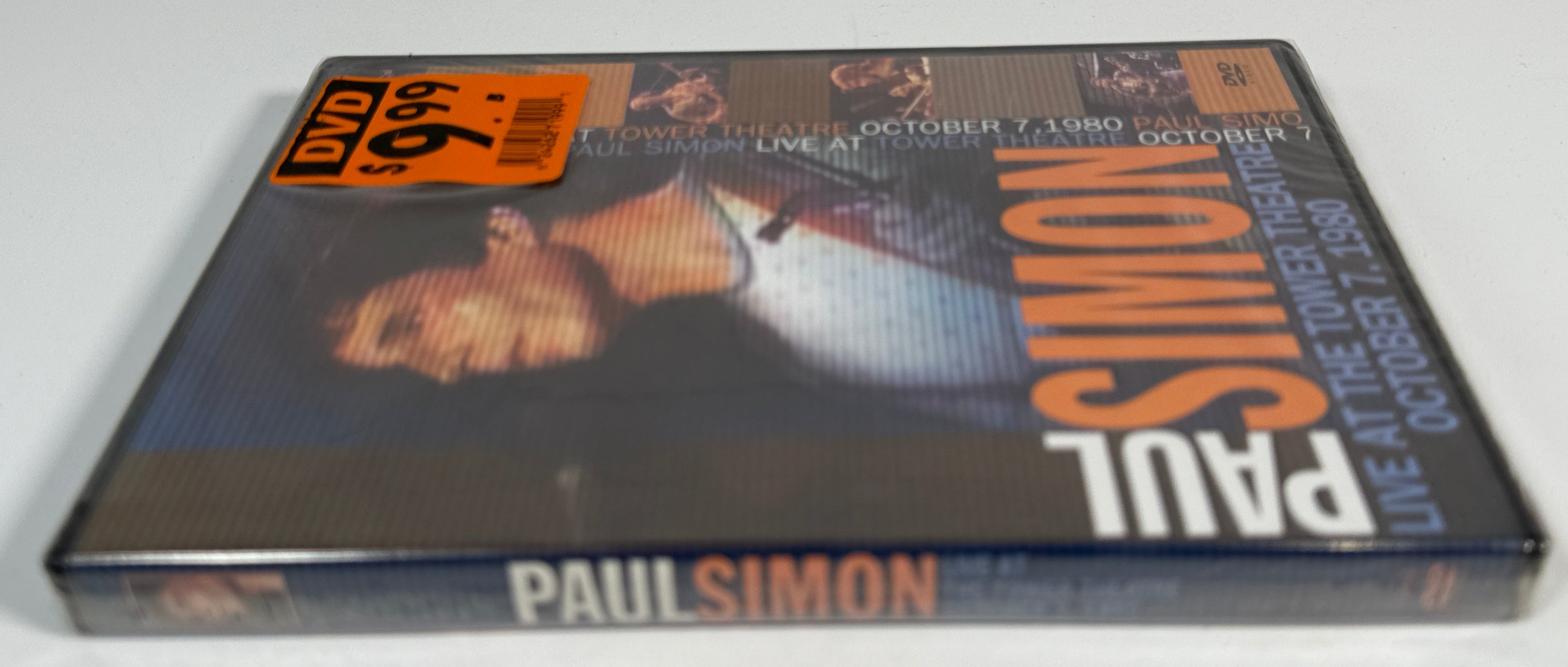 Paul Simon DVD cover on a white surface with a gray tiled background