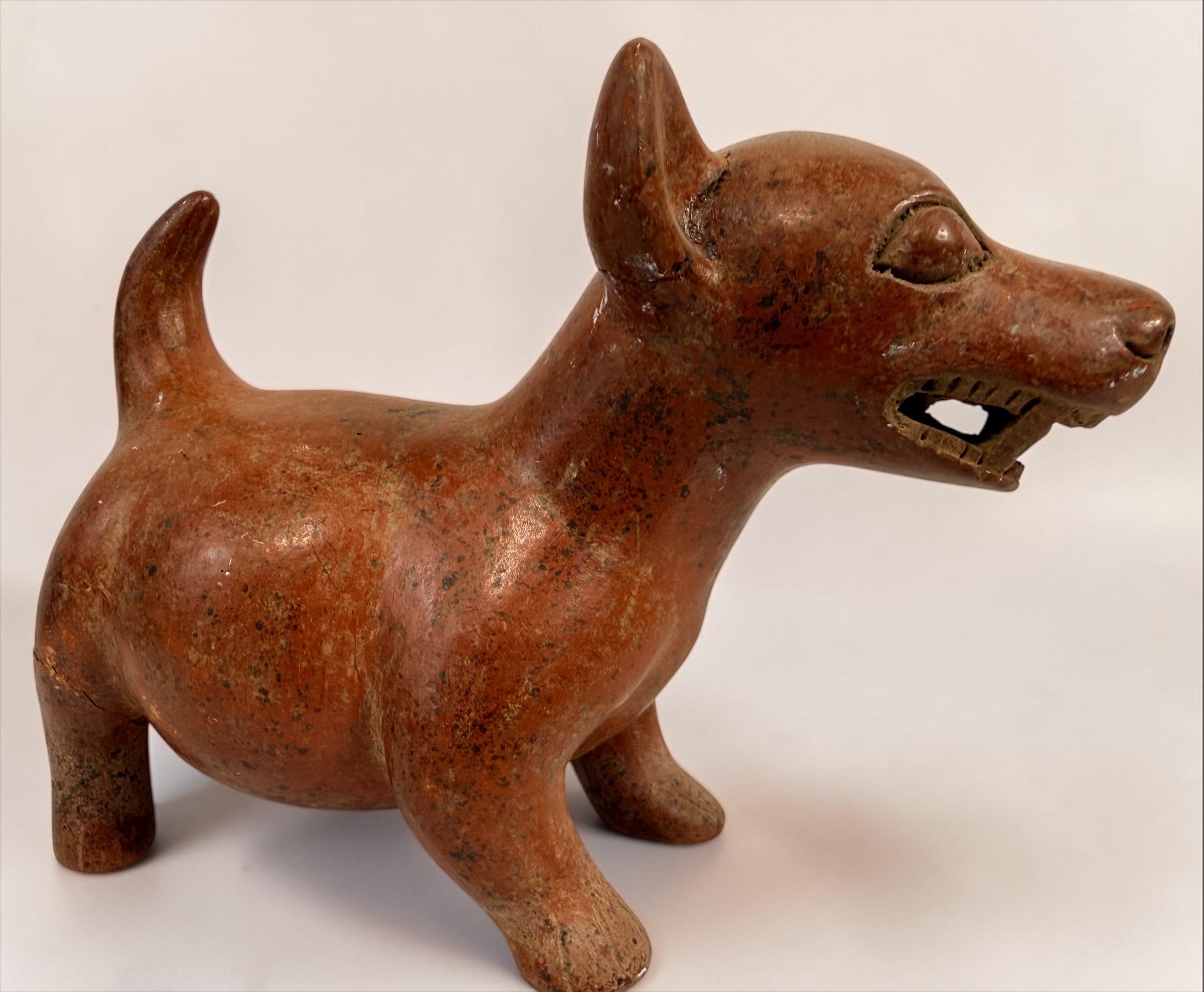 Vintage Mexican Colima-style redware pottery dog with aged patina, expressive teeth and GP mark. Decorative pre-Columbian revival folk art.