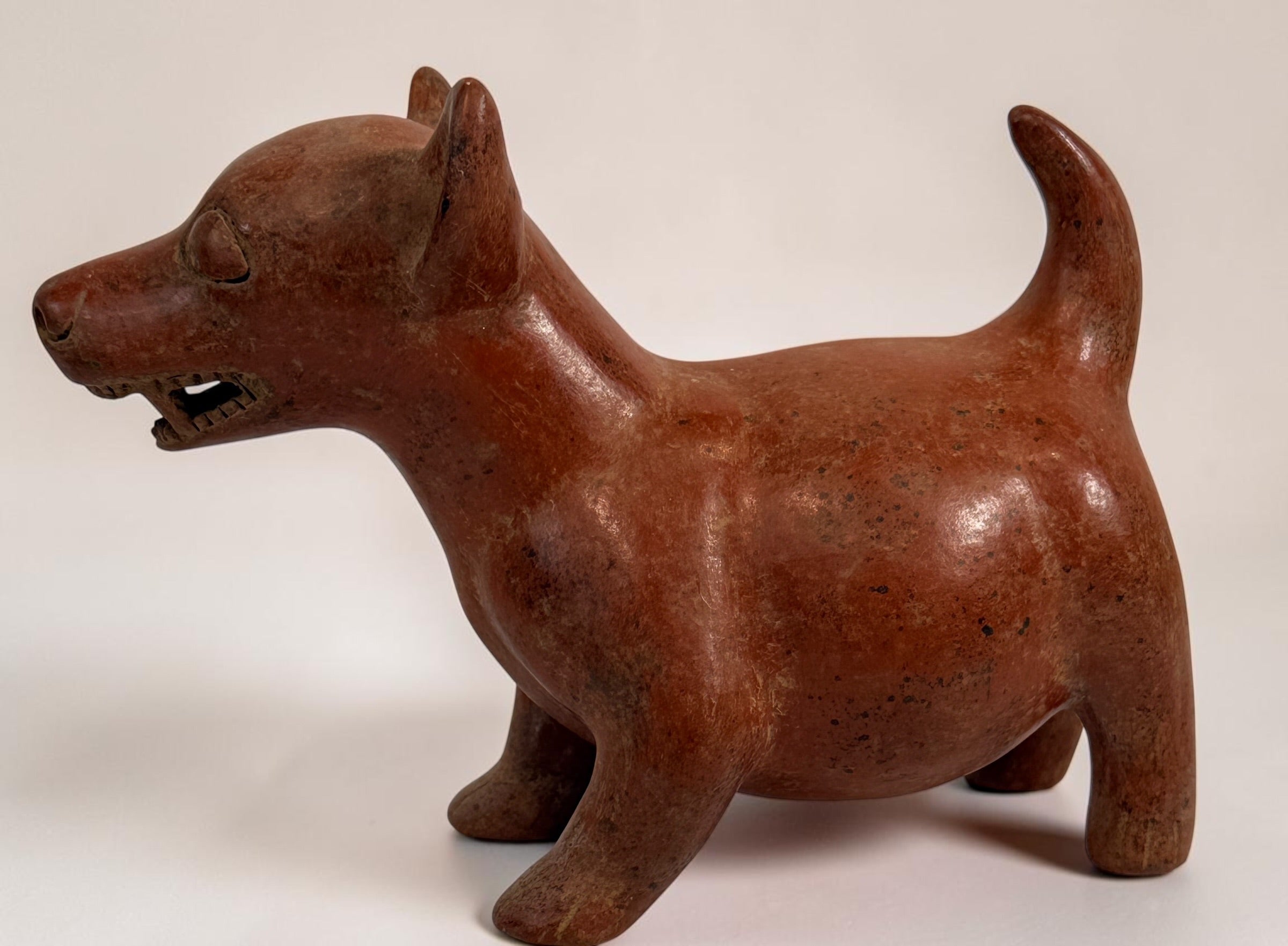 Vintage Mexican Colima-style redware pottery dog with aged patina, expressive teeth and GP mark. Decorative pre-Columbian revival folk art.