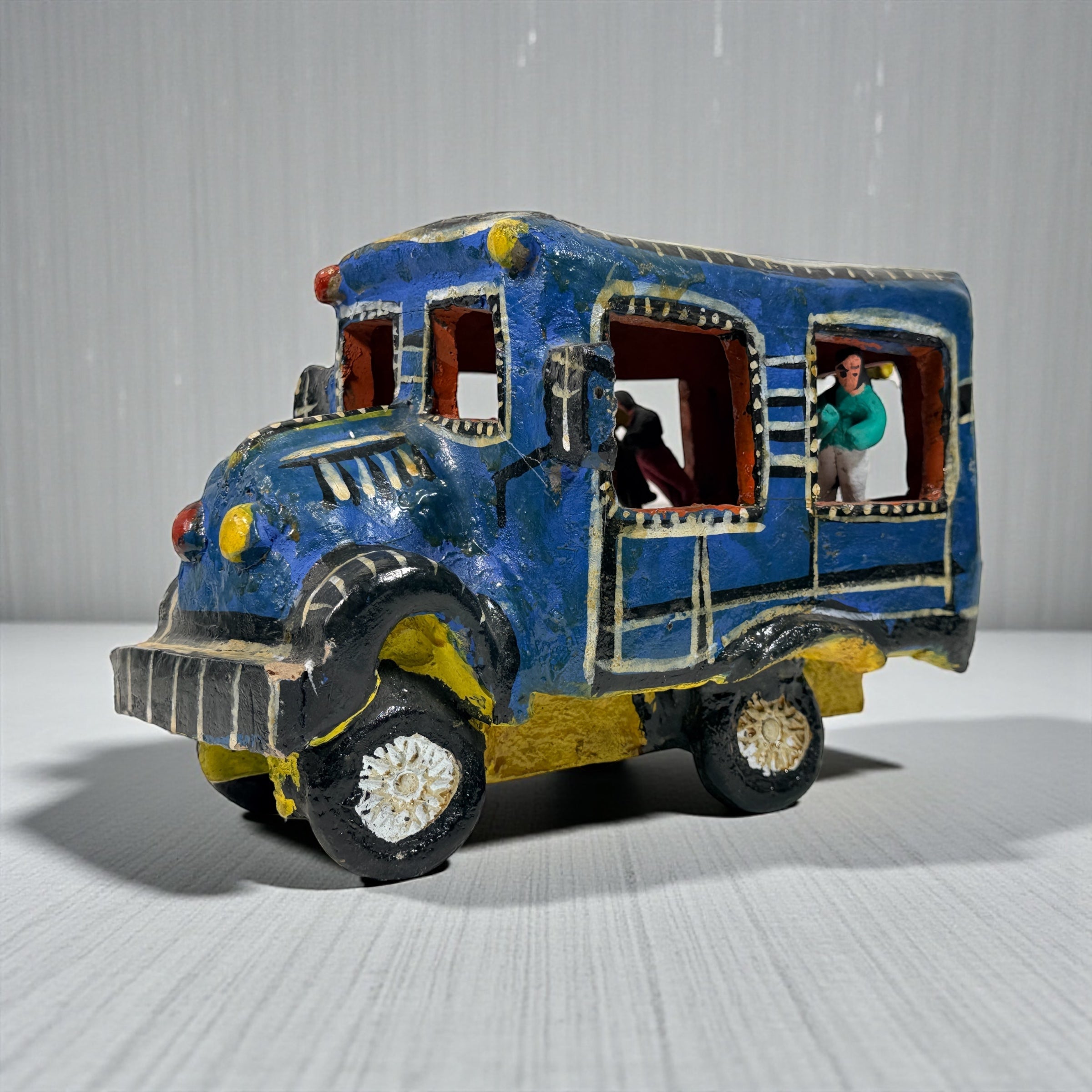 Vintage Mexican papier-mâché colectivo bus sculpture with hand-modeled interior figures. Folk art narrative piece with bold color and strong display presence.