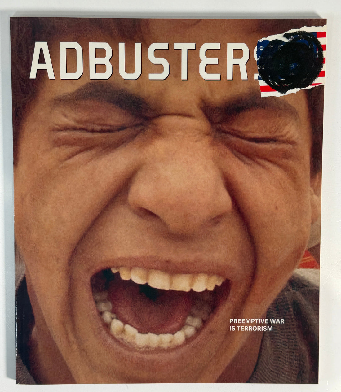 Magazine cover with a close-up of a person's mouth and the word 'ADBUSTER' visible.