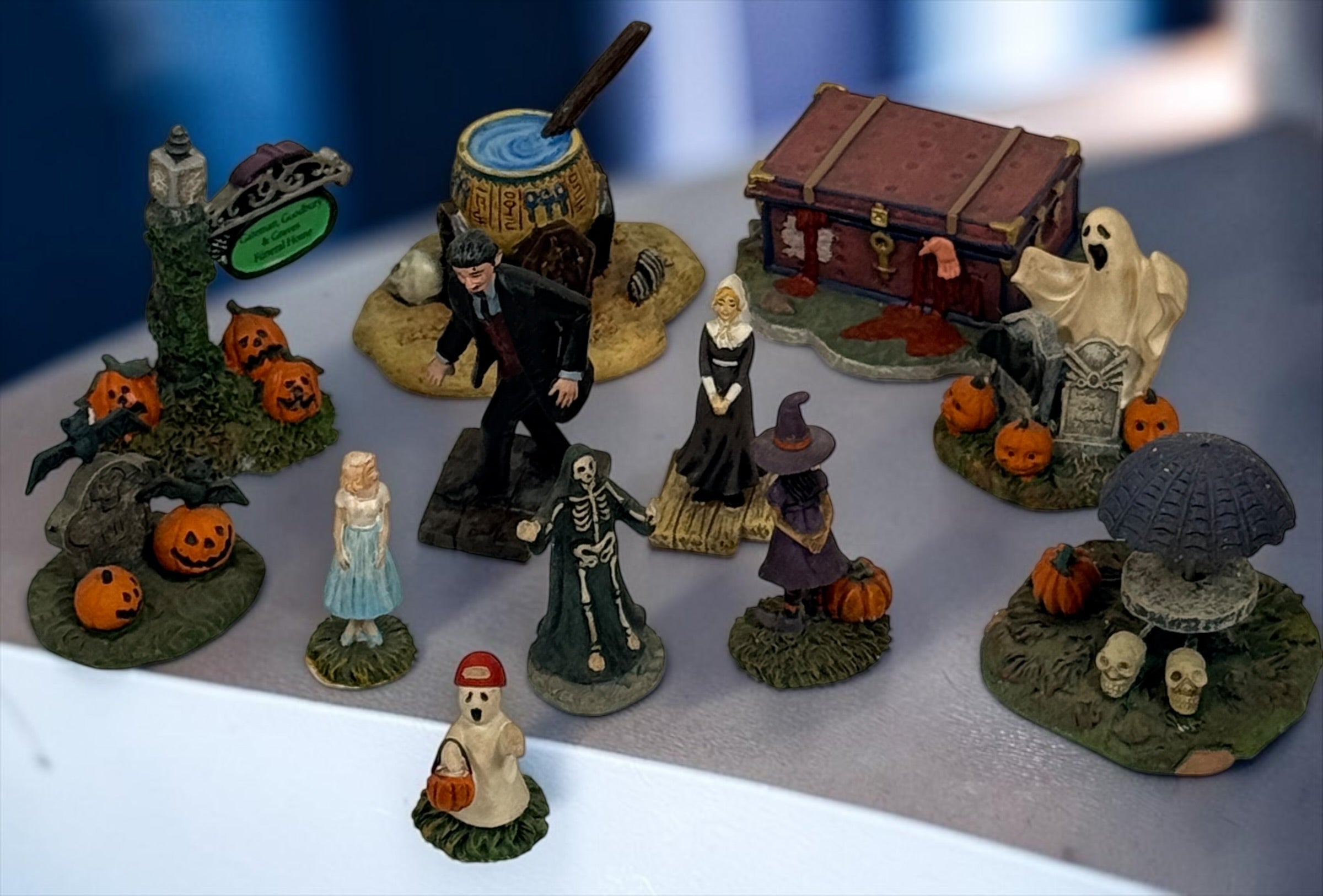 Hawthorne Village The Munsters Halloween Village 12-piece resin accessory lot with figures, pumpkins, ghosts, witch, cauldron and graveyard scenes.