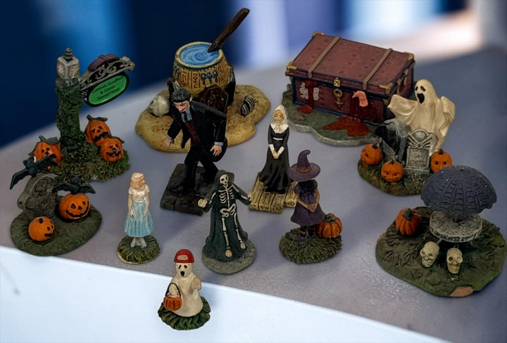 Hawthorne Village The Munsters Halloween Village 12-piece resin accessory lot with figures, pumpkins, ghosts, witch, cauldron and graveyard scenes.