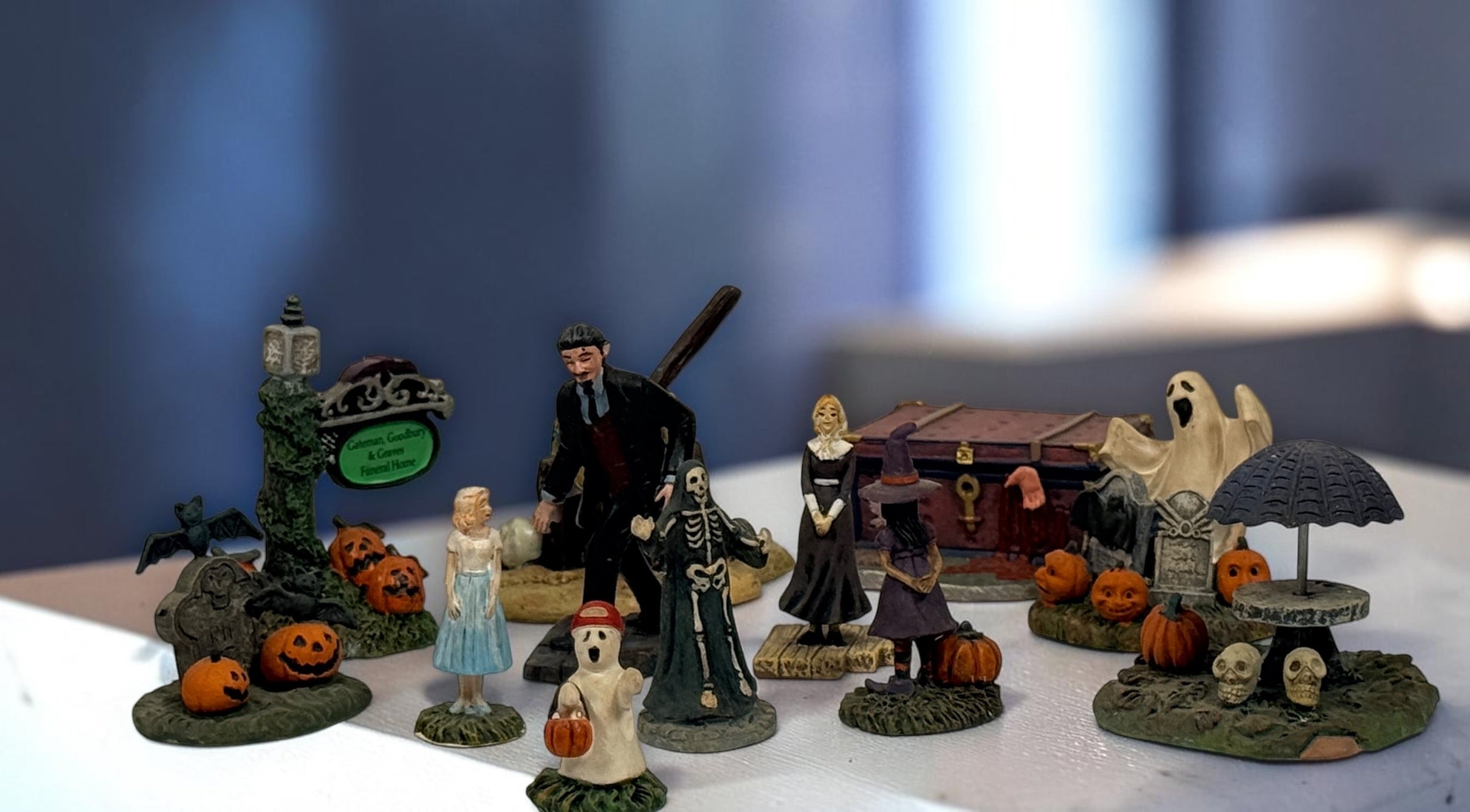 Hawthorne Village The Munsters Halloween Village 12-piece resin accessory lot with figures, pumpkins, ghosts, witch, cauldron and graveyard scenes.