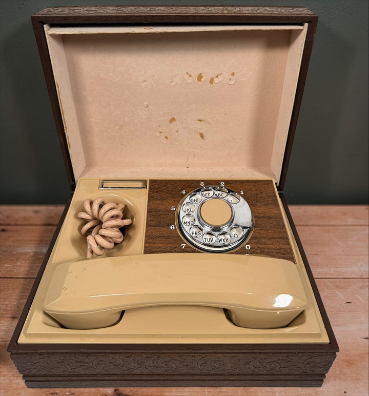 Vintage 1970s Deco-Tel rotary telephone hidden inside a decorative carved-look wood chest. Untested with cut line cord; sold as-is.