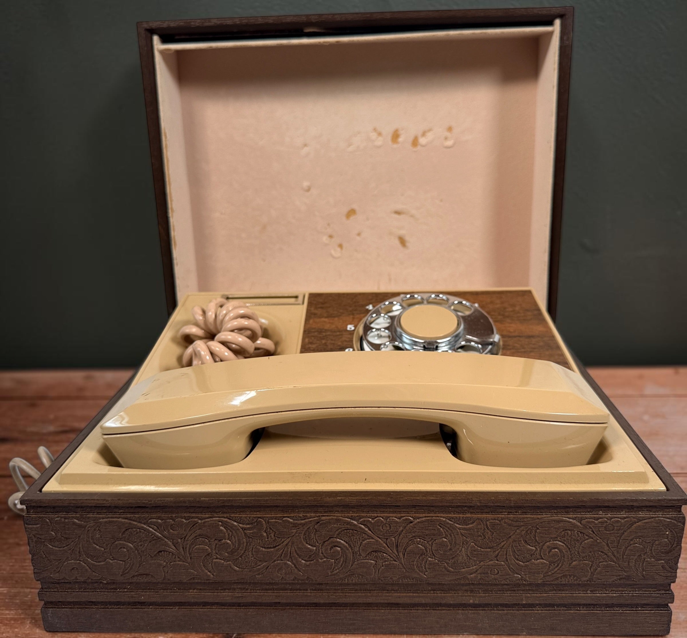 Vintage 1970s Deco-Tel rotary telephone hidden inside a decorative carved-look wood chest. Untested with cut line cord; sold as-is.