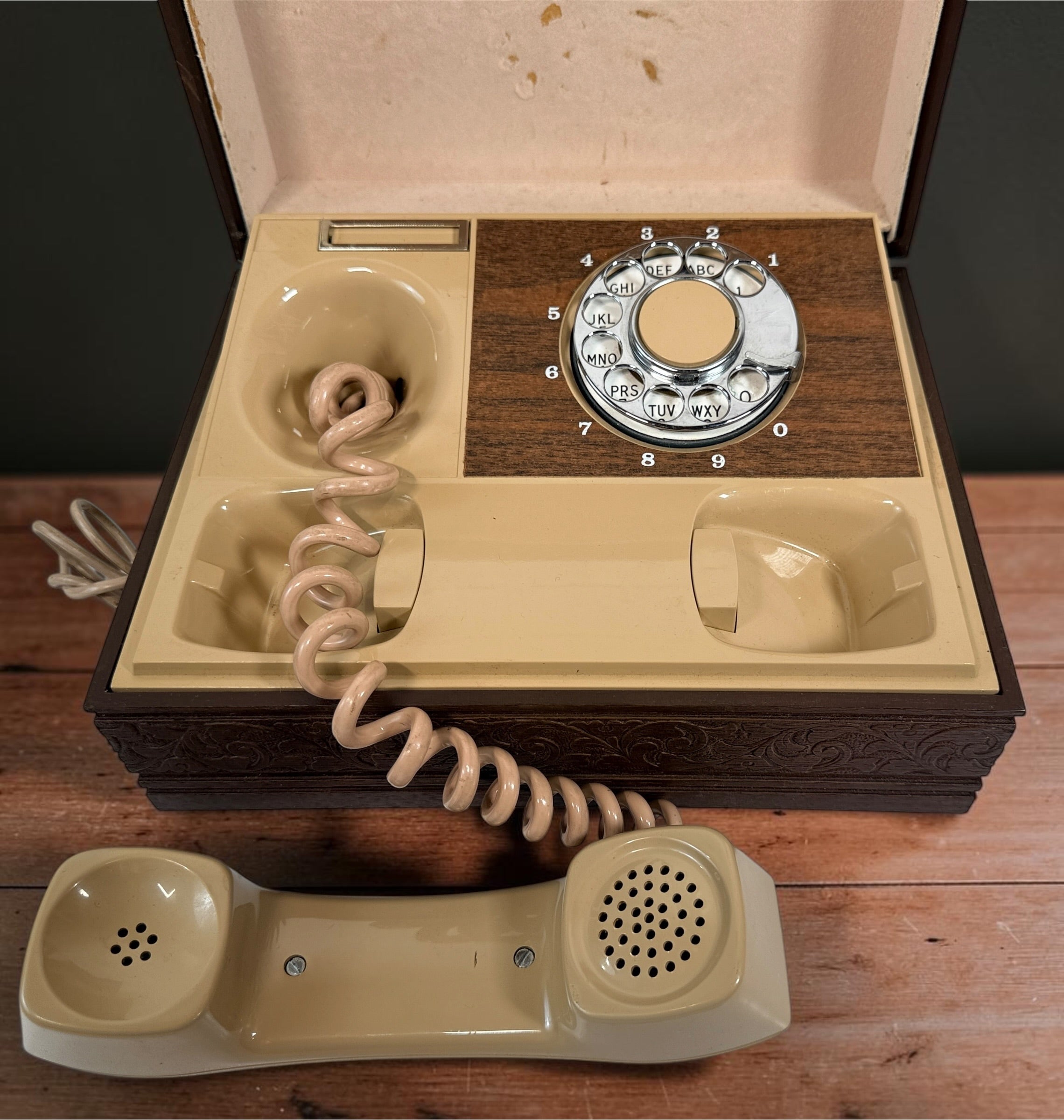 Vintage 1970s Deco-Tel rotary telephone hidden inside a decorative carved-look wood chest. Untested with cut line cord; sold as-is.