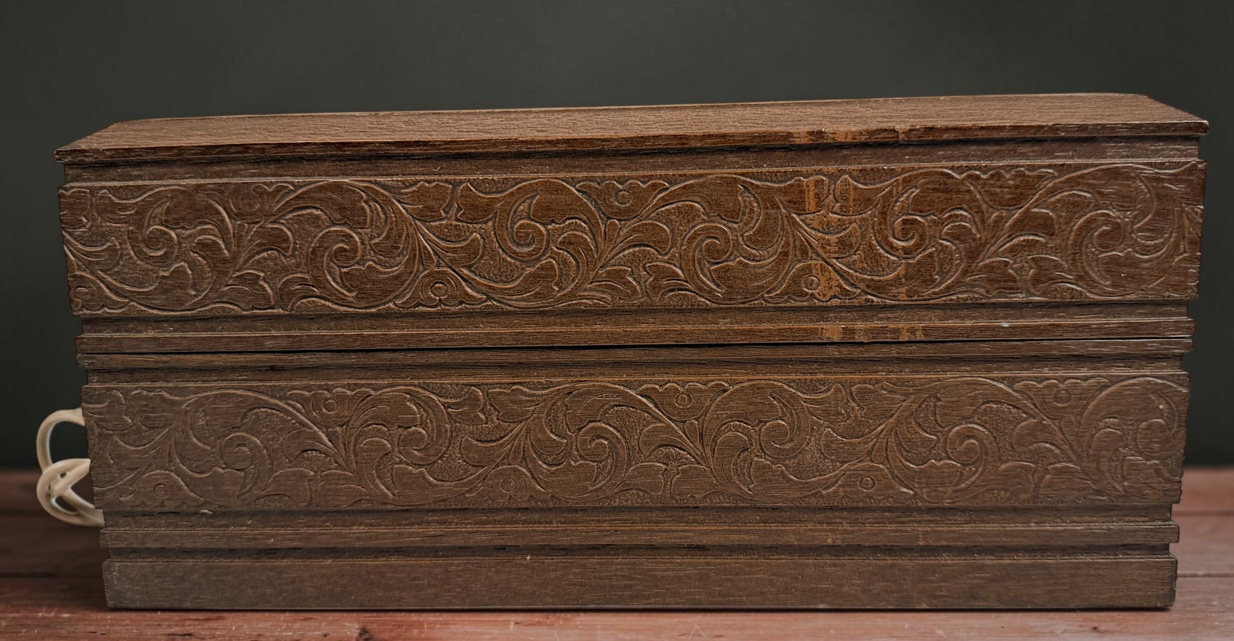 Vintage 1970s Deco-Tel rotary telephone hidden inside a decorative carved-look wood chest. Untested with cut line cord; sold as-is.