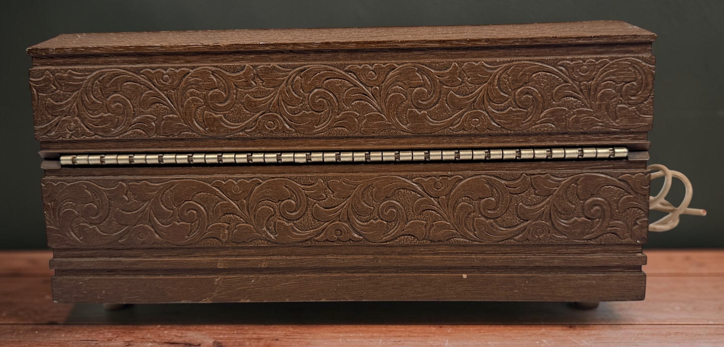Vintage 1970s Deco-Tel rotary telephone hidden inside a decorative carved-look wood chest. Untested with cut line cord; sold as-is.